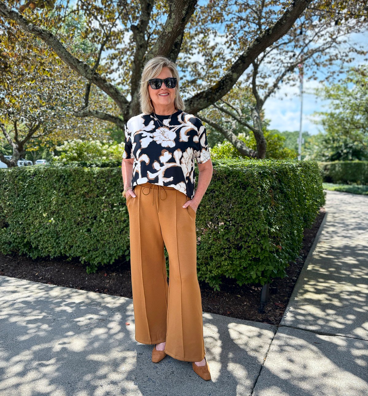 Tania wearing an air-knit short sleeve floral top with pleated pants from Talbots 