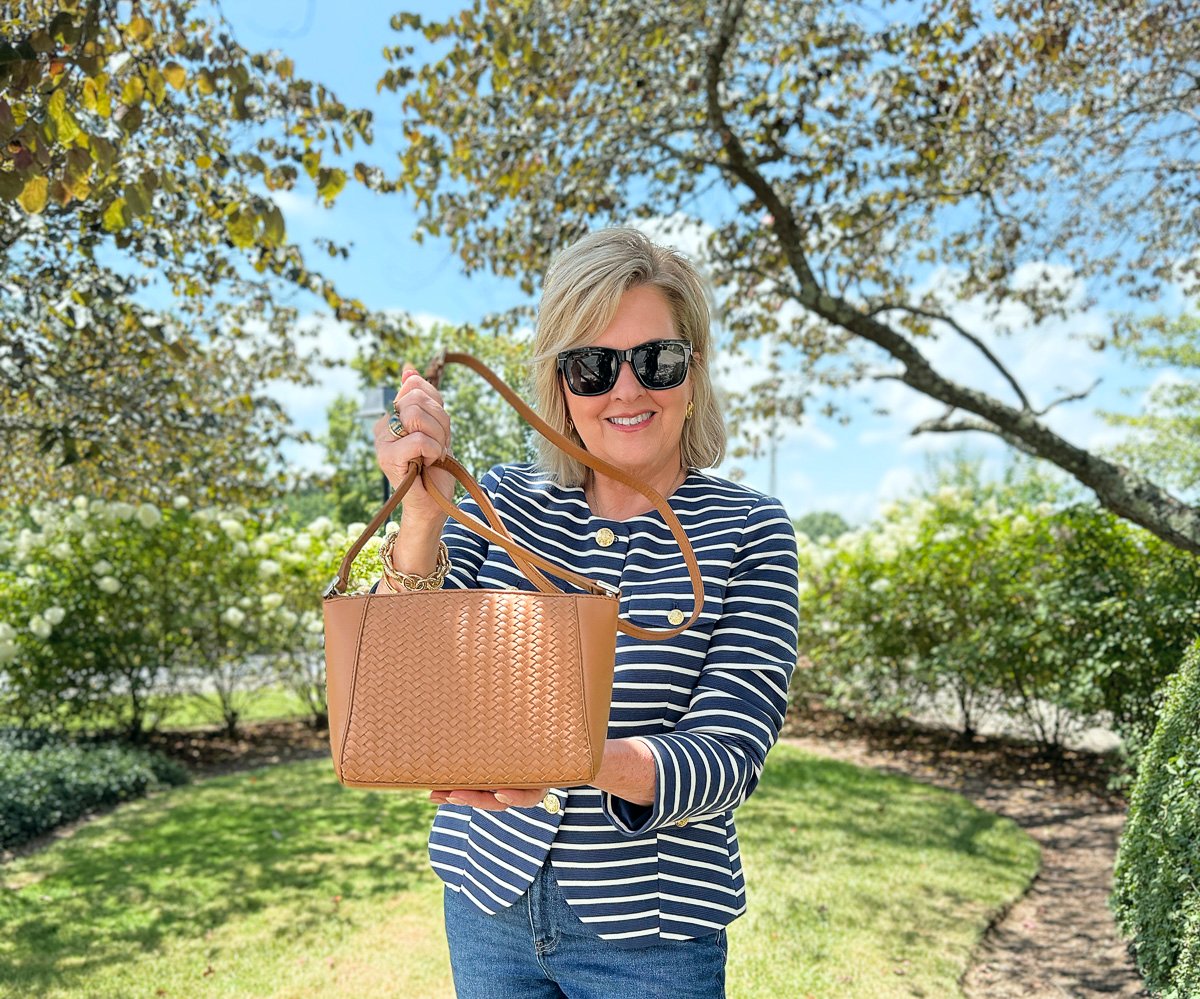 Woven leather crossbody bag with stripe jacket and jeans for a chic fall transition look