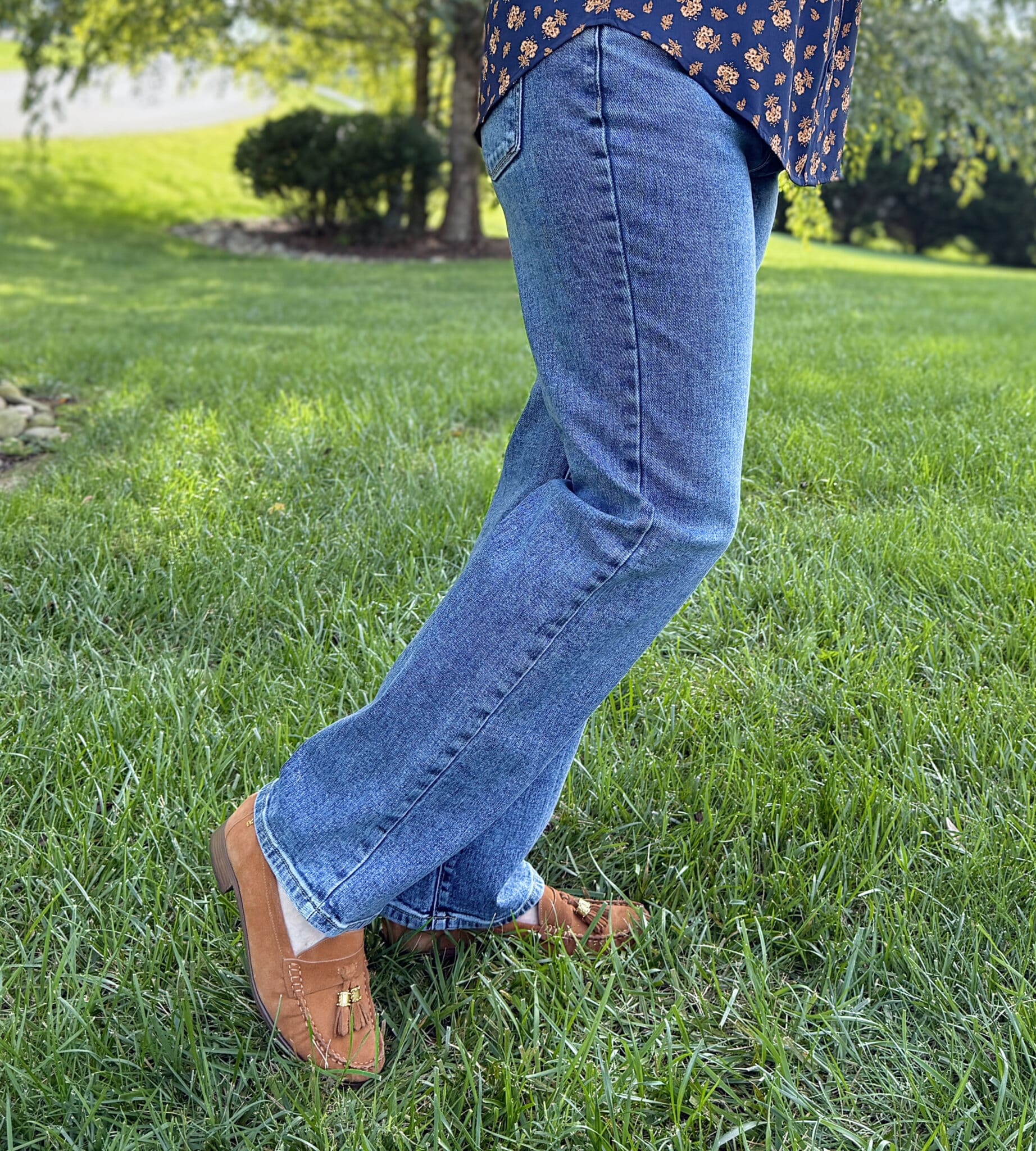 Woman over 50 standing in a grassy field in Lauren Conrad straight leg jeans from Kohl's