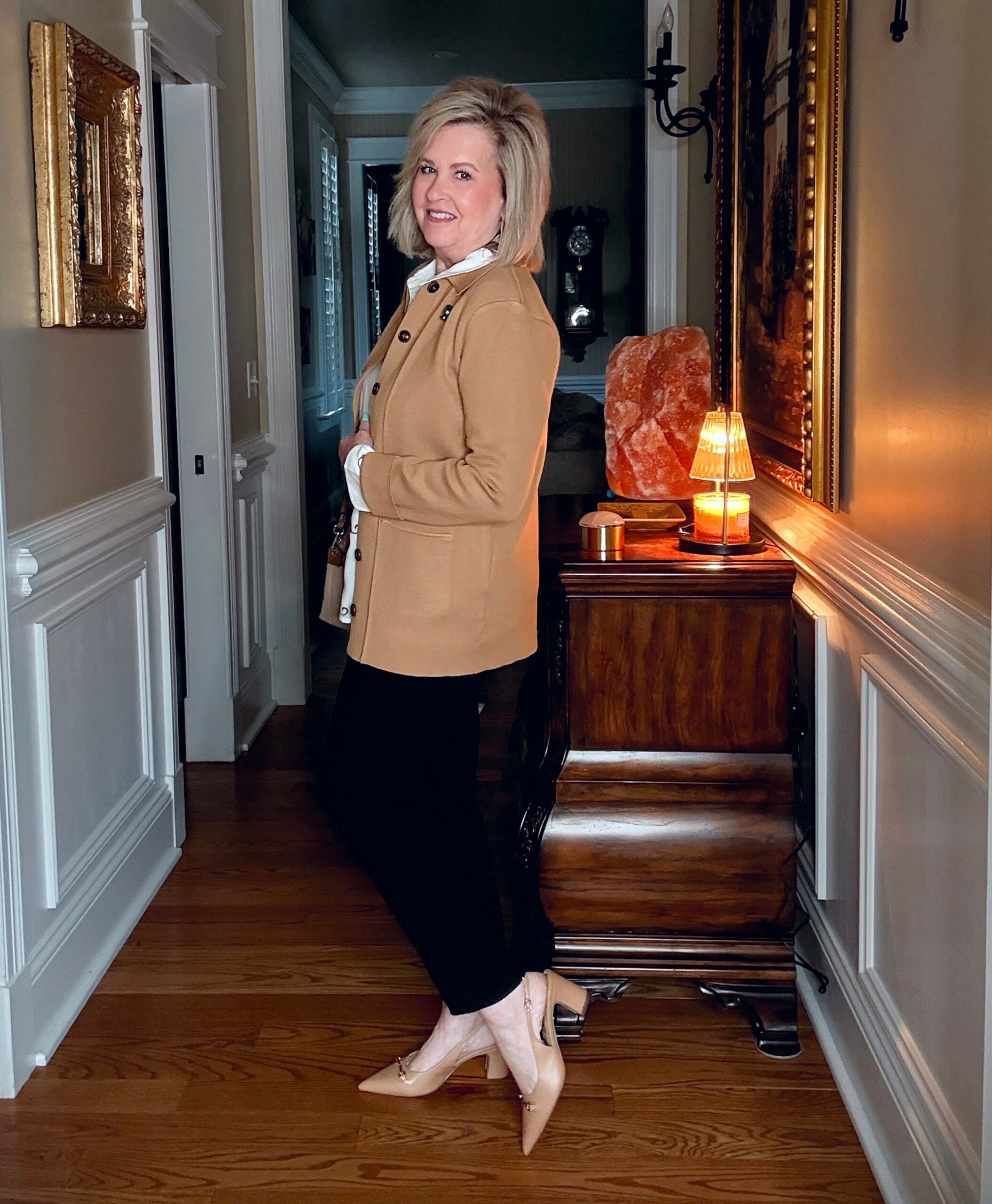 Tania wearing a cheetah button up shirt with a knit blazer, black pants, and neutral shoes