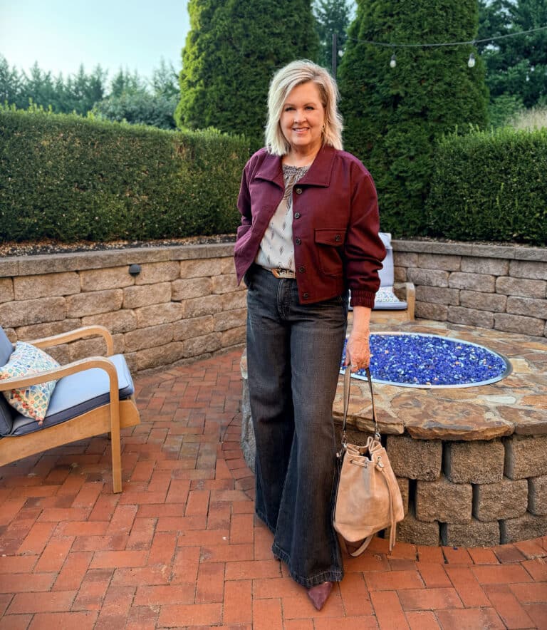 Tania wearing a burgundy bomber jacket and black/gray jeans from Loft