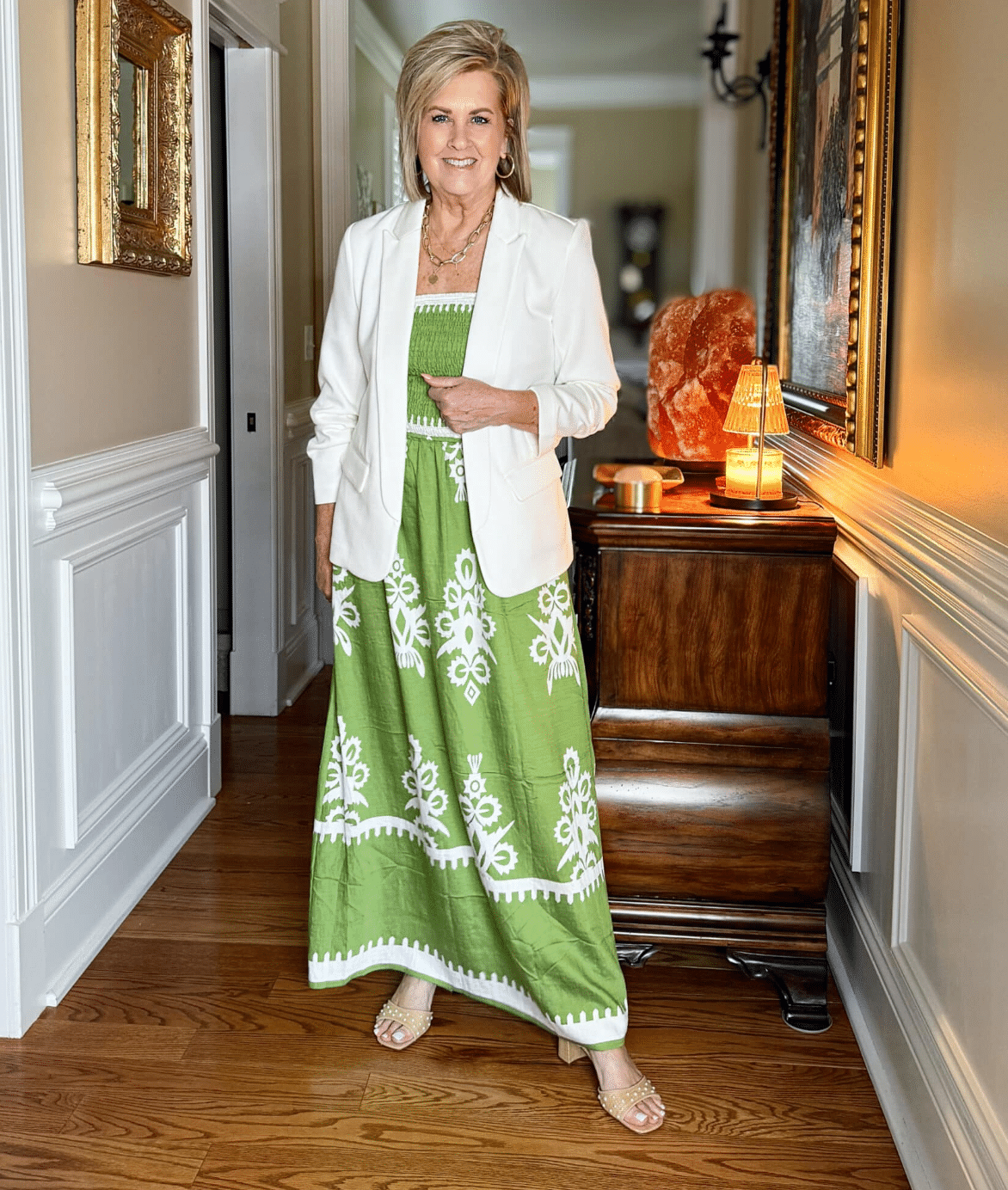Tania Stephens styled in a floral boho maxi dress layered with a white scrunched-sleeve blazer, accessorized with hoop earrings and woven pearl heels.