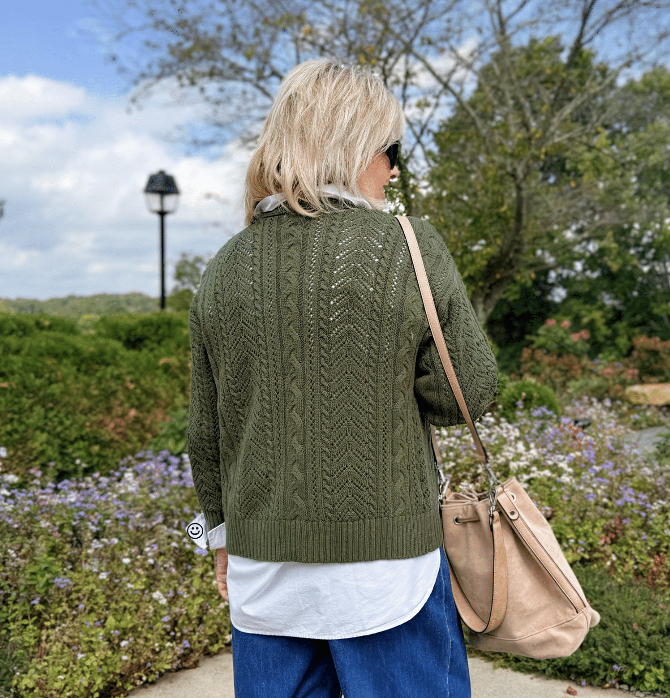 Tania Stephens showing the back of a Walmart green Pointelle cardigan