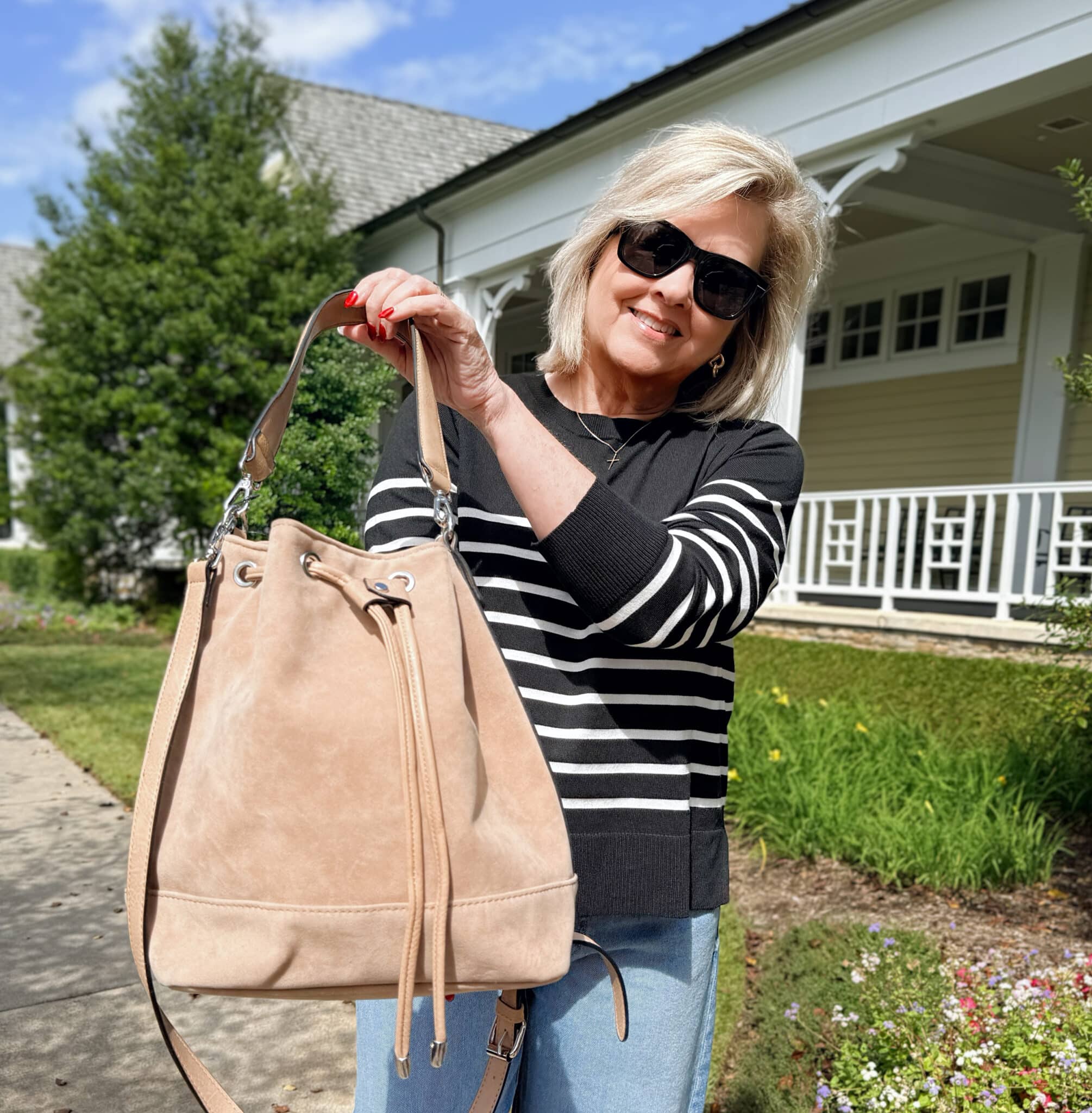 Tania Stephens is in a Walmart black and white sweater with a suede bucket bag