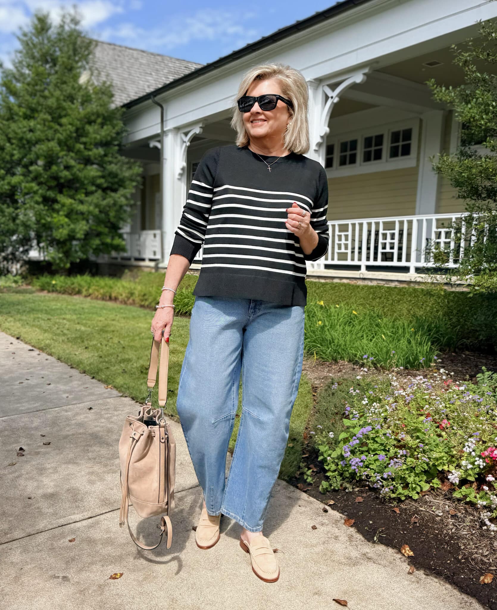 Tania Stephens wearing a Walmart black sweater with white stripes and barrel jeans