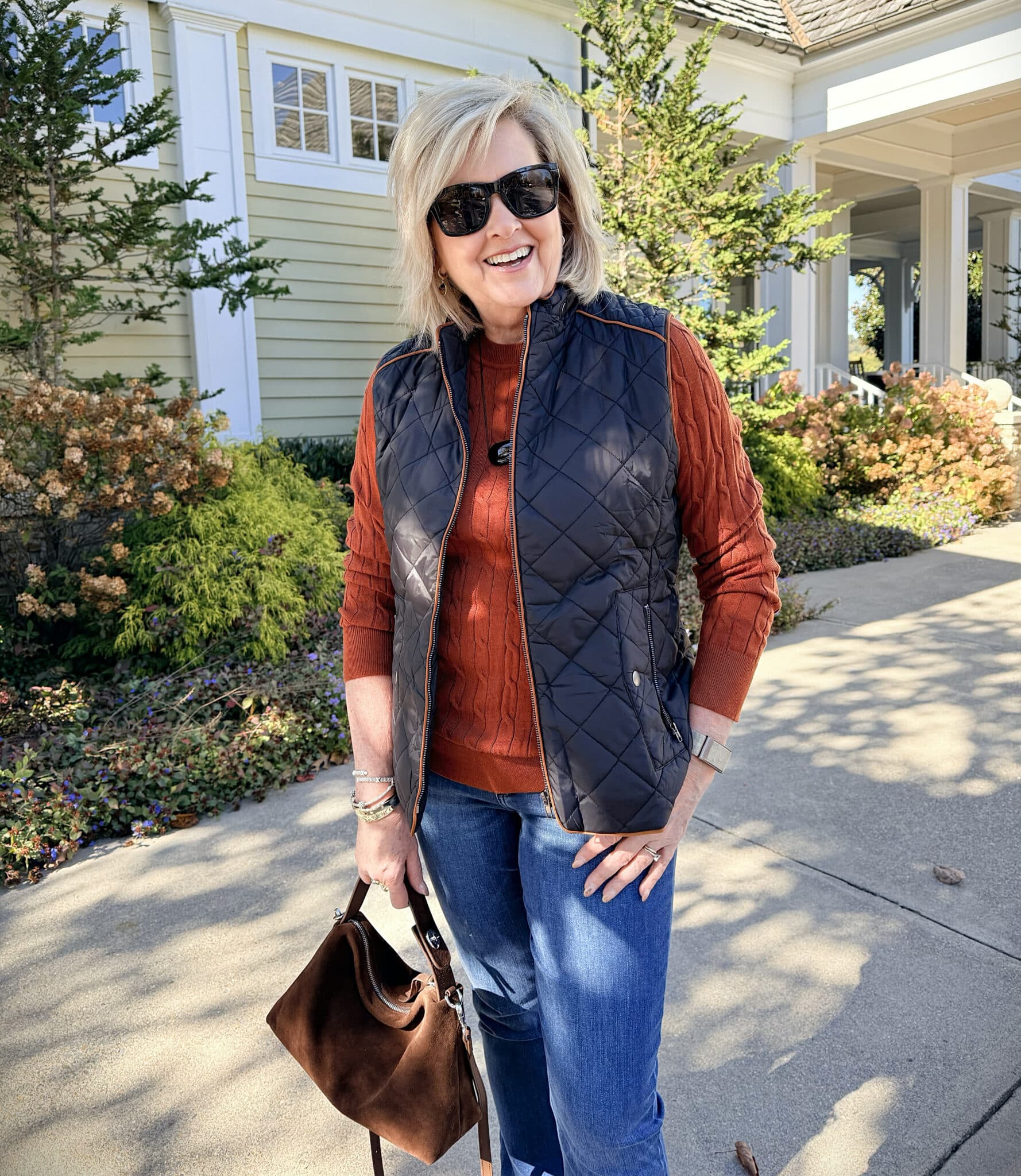 Tania is an Amazon black quilted vest with rust sweater