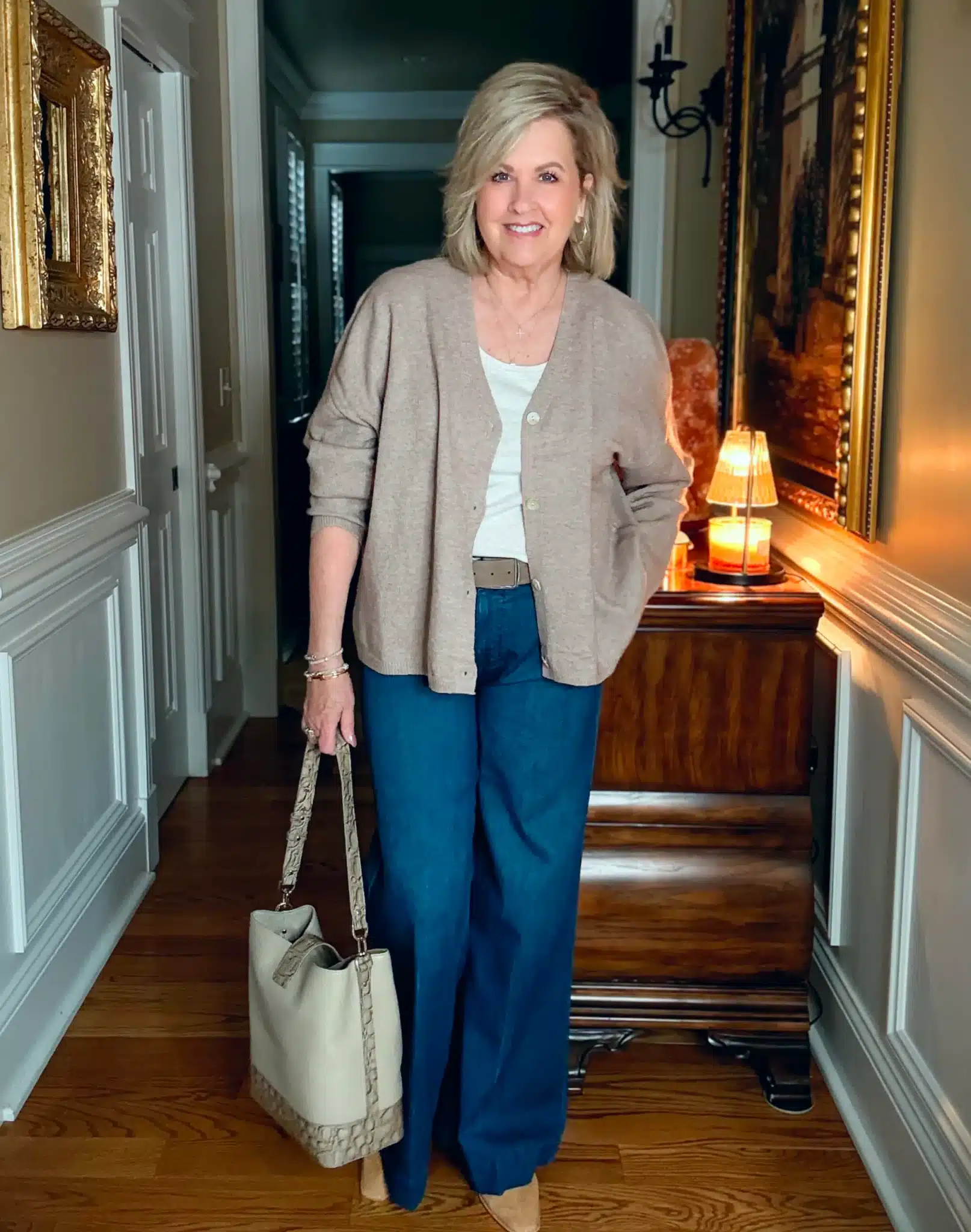 Woman styling an oversized cardigan for fall with jeans and boots