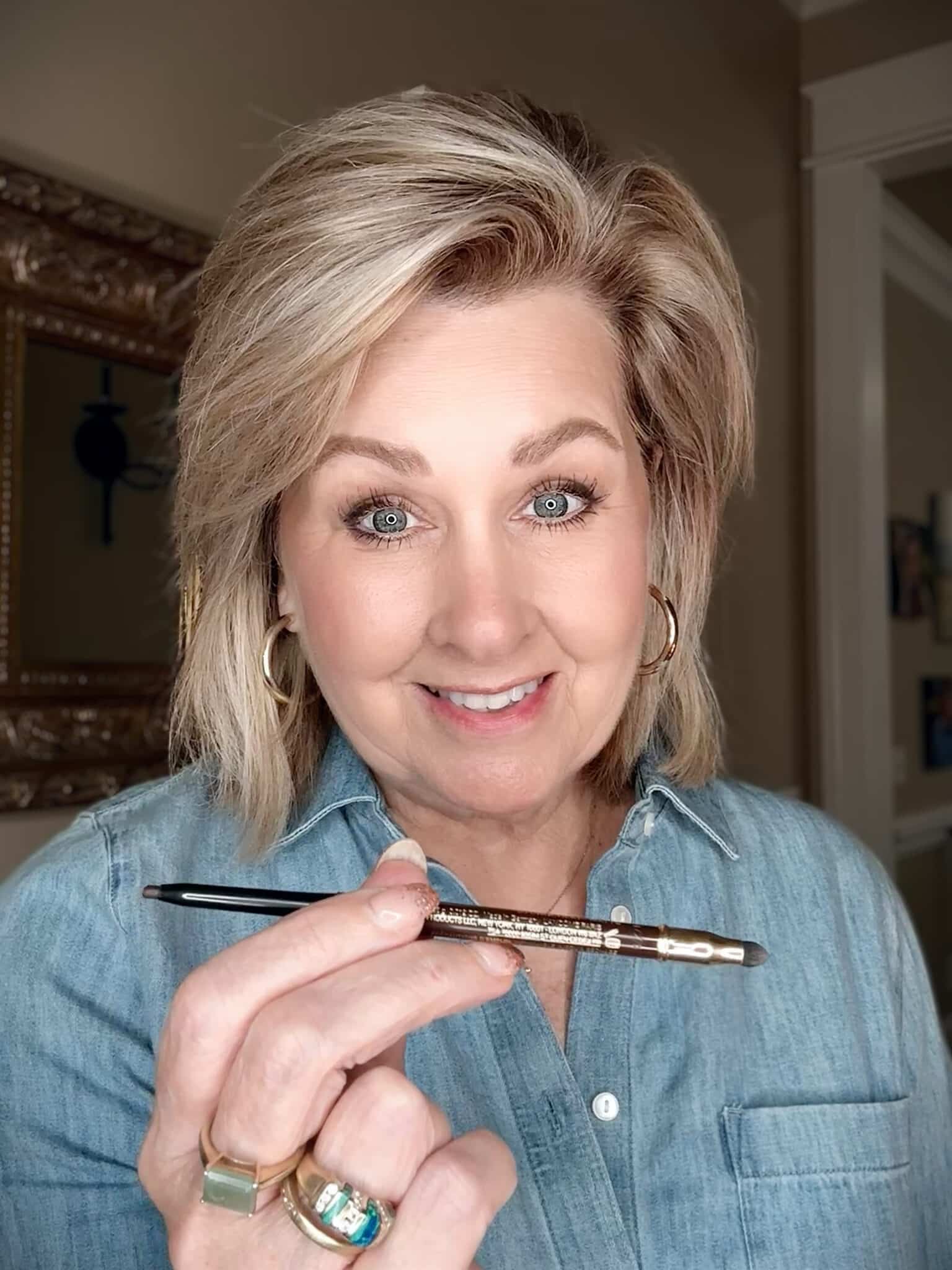 Casual shot of woman holding the Lancôme Le Stylo Waterproof Eyeliner in Chocolate.