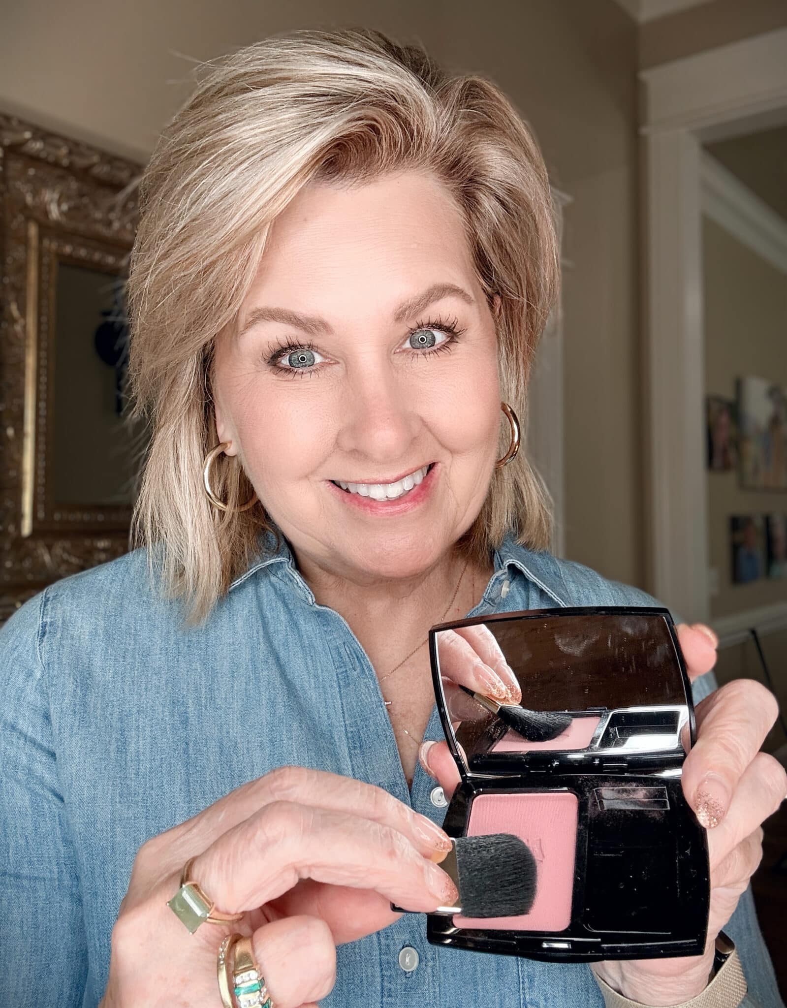 Woman applying or showing the Lancôme Blush Subtil in Rose Fresque with a makeup brush.