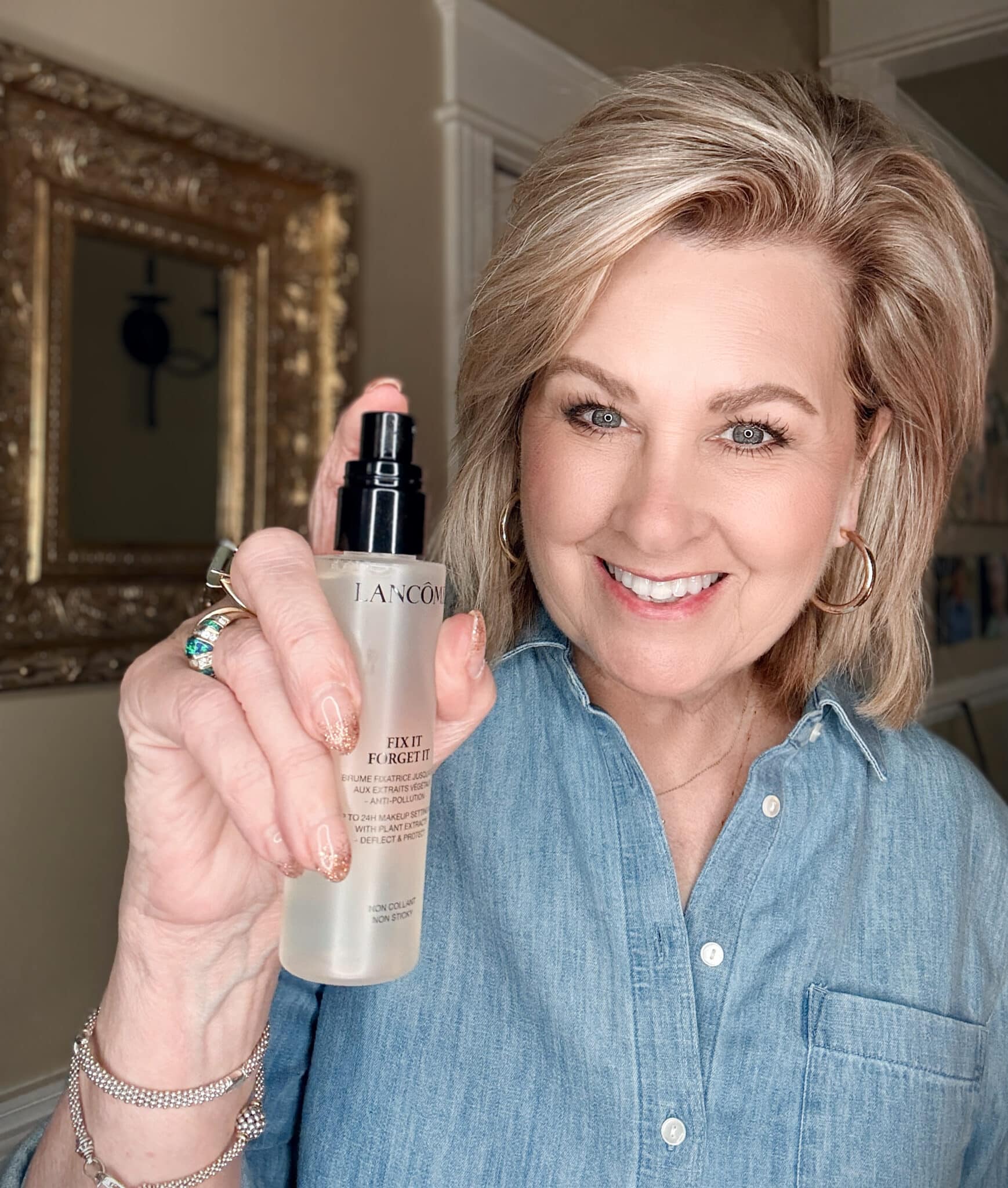 Woman holding the clear bottle of Lancôme Fix It Forget It Setting Spray.