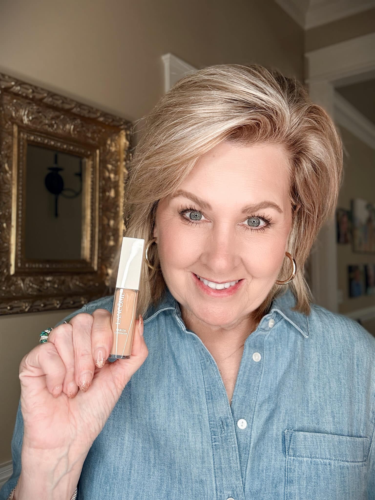 Woman holding the blue bottle of Lancôme Teint Idole Ultra Wear Care & Glow Serum Concealer from Nordstrom Beauty