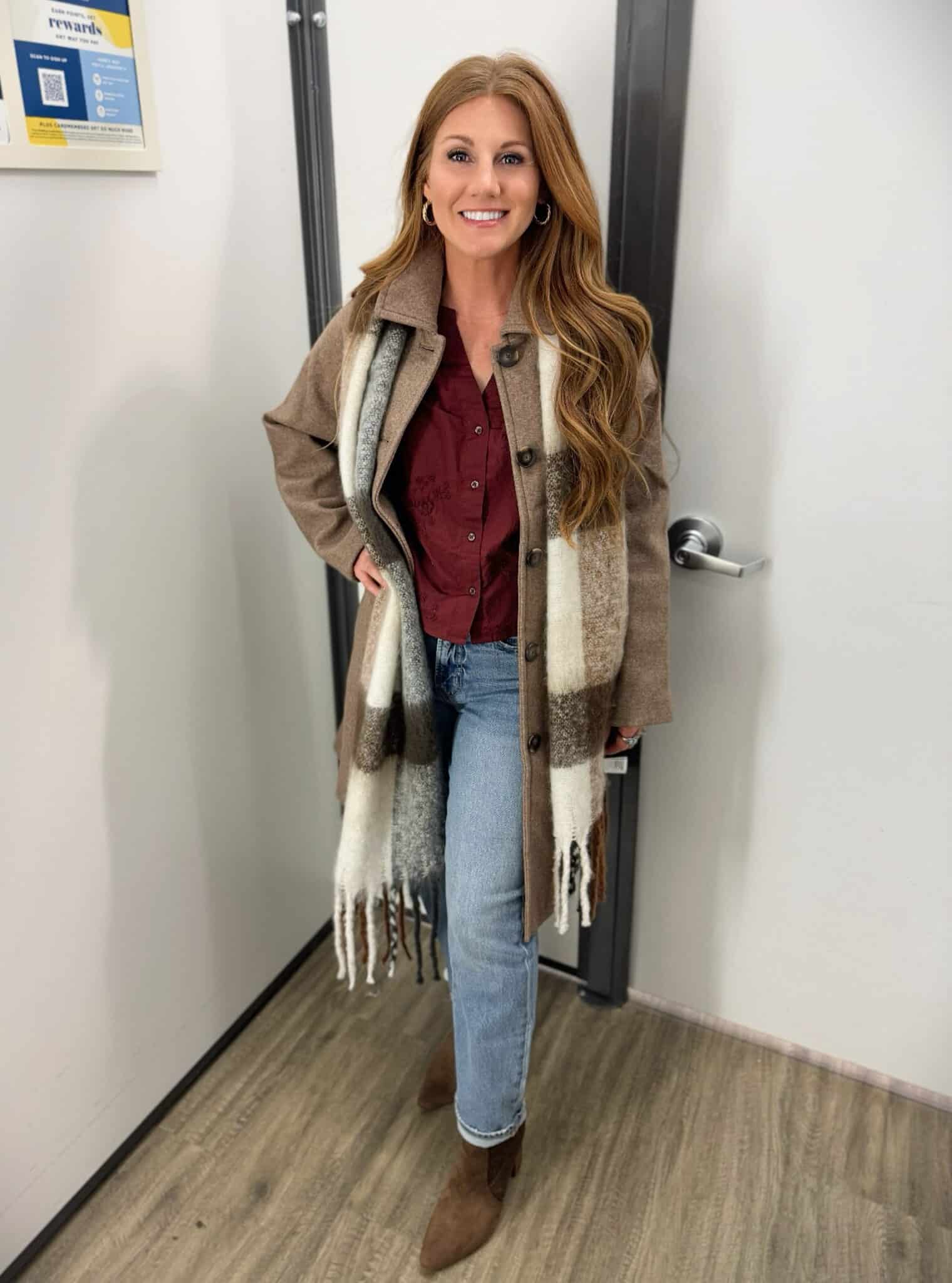 Stephanie in a brown coat with a plaid fuzzy scarf and jeans from Old Navy