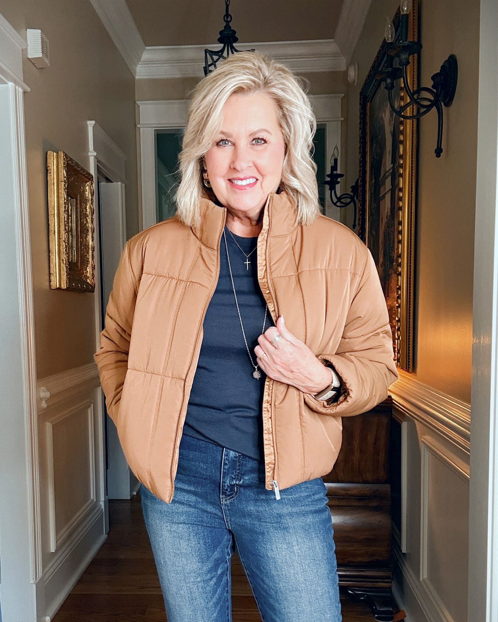 Tania wearing a navy tee with a caramel short puffer jacket from  Travis Mathews