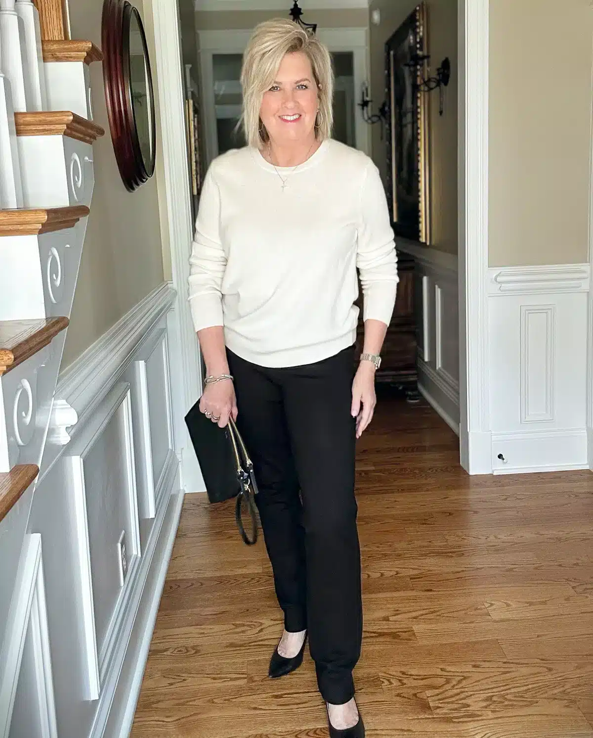 WOMAN OVER 50 WEARING A SOFT CASHMERE SWEATER FROM QUINCE WITH BLACK PANTS FOR WINTER FALL 
