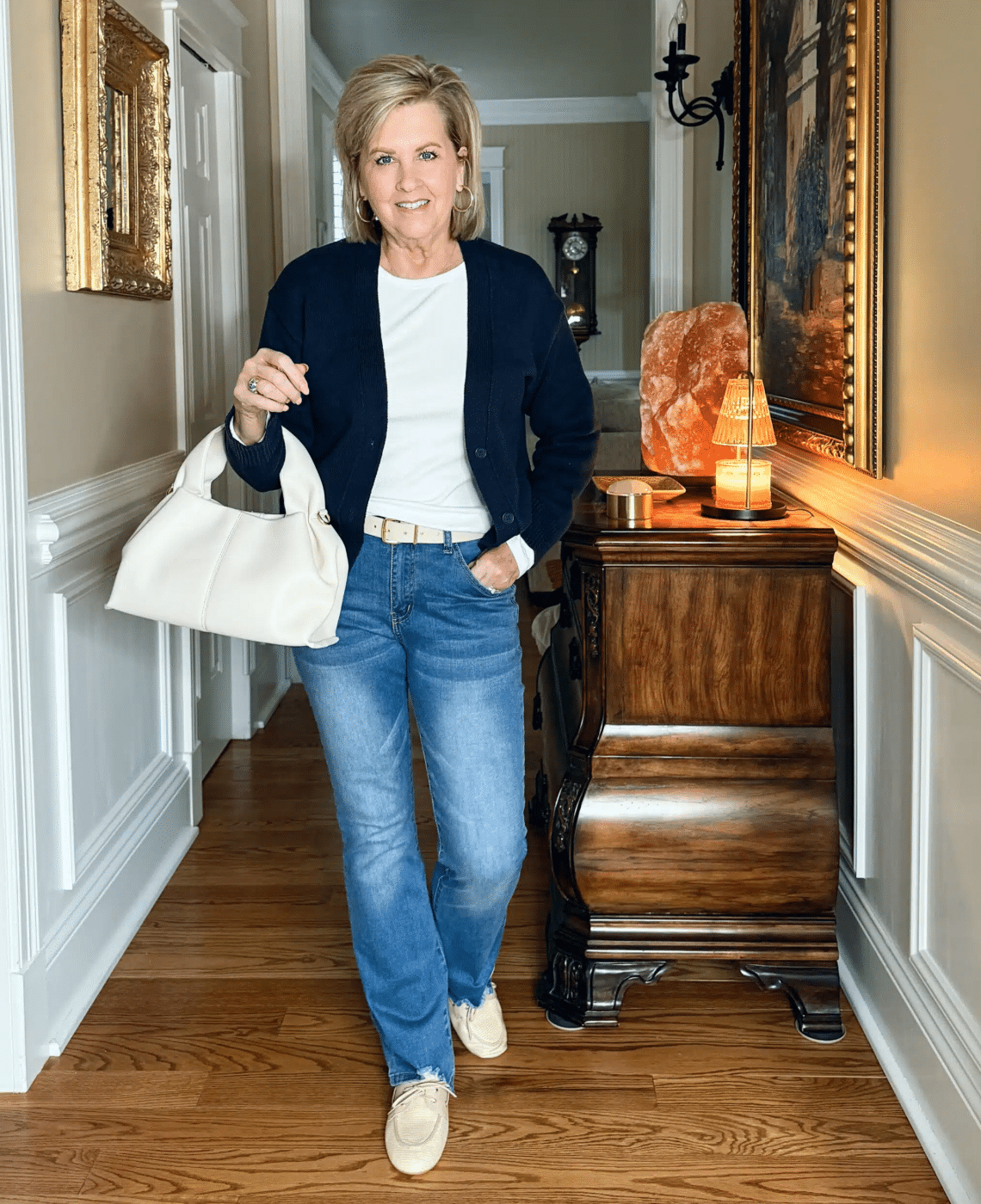 Tania wearing a white tee, a navy cardigan and jeans