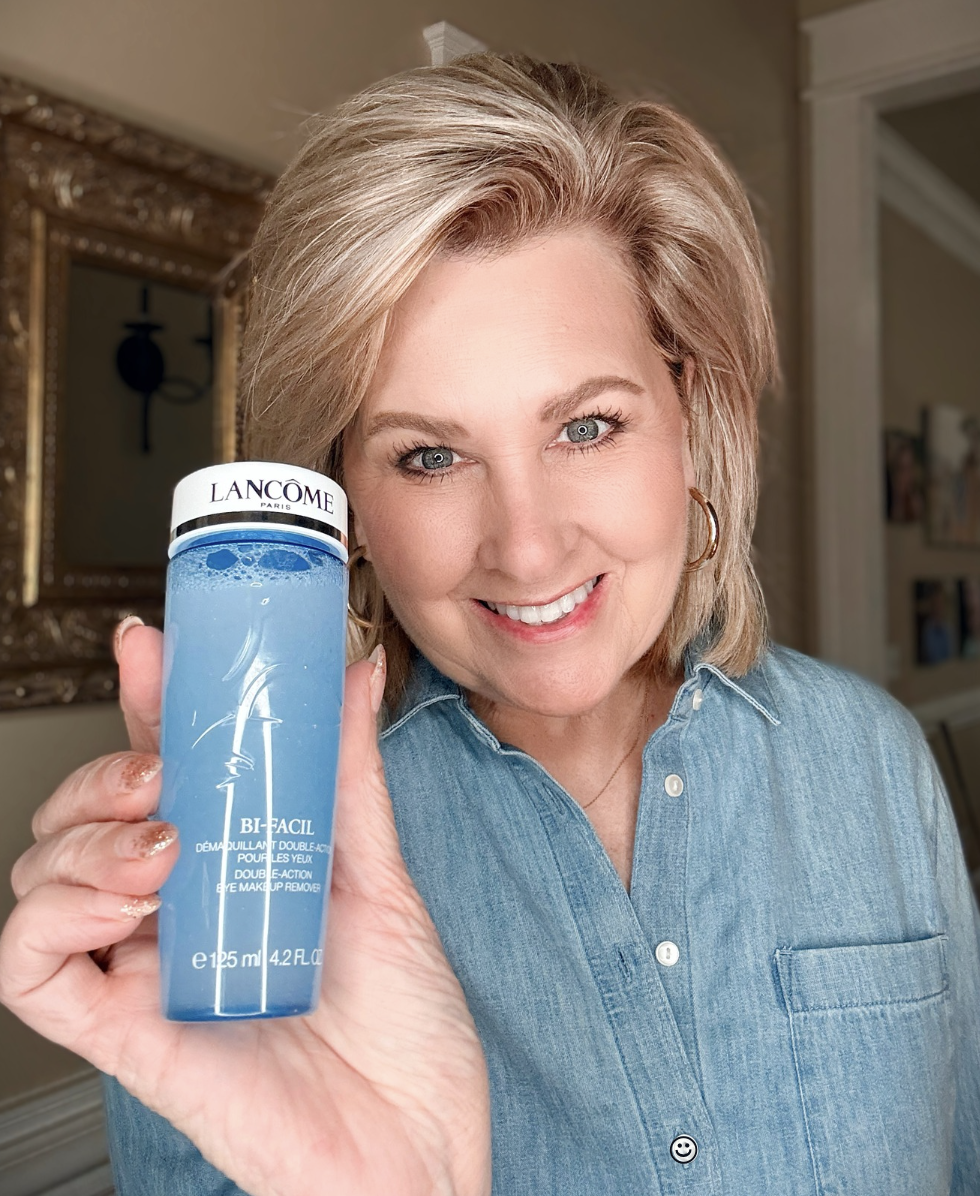 Woman holding the blue bottle of Lancôme Bi-Facil Double-Action Eye Makeup Remover.