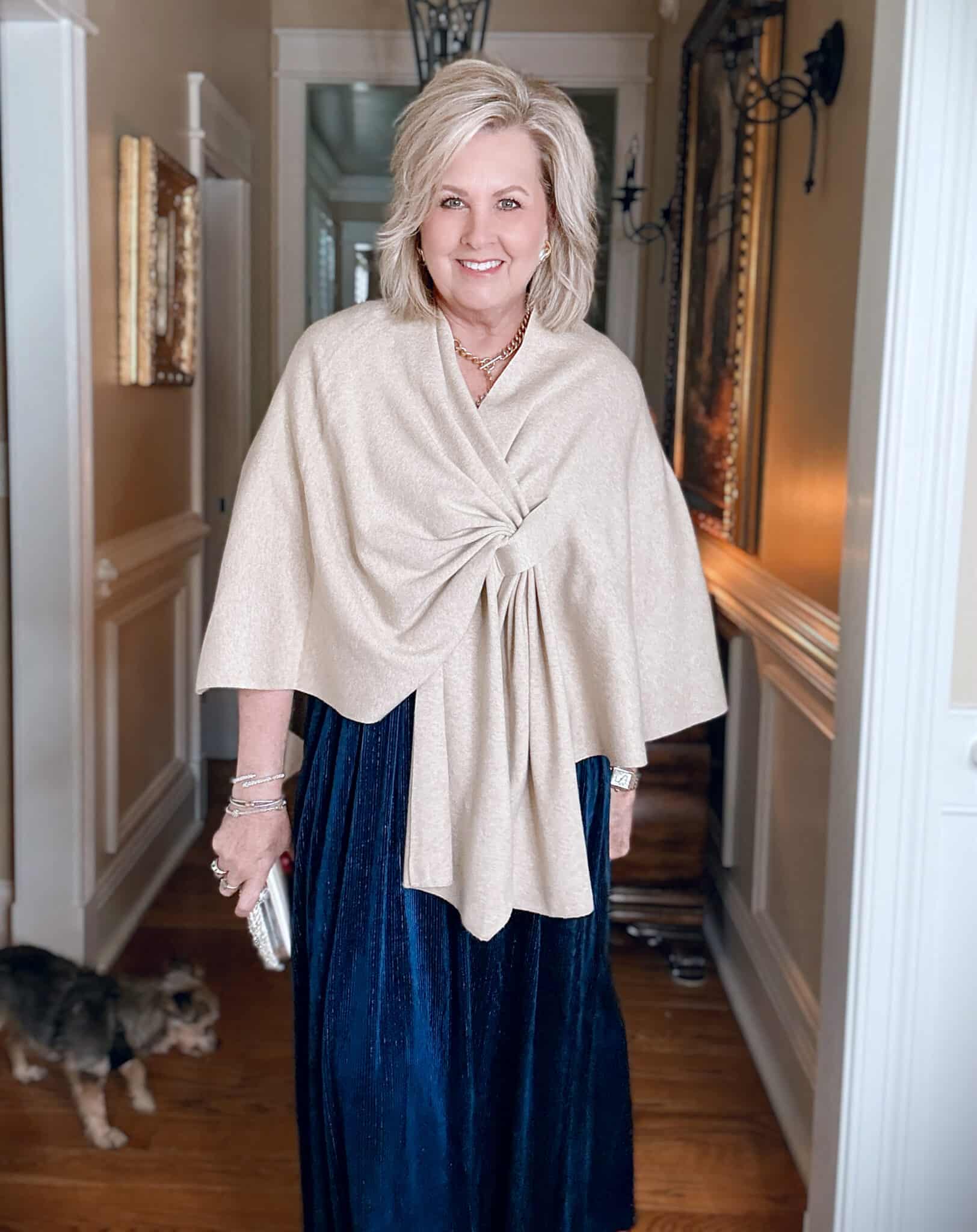 Tania wearing a wrap over a V-Neck Amazon blue velvet dress with a metallic stripe