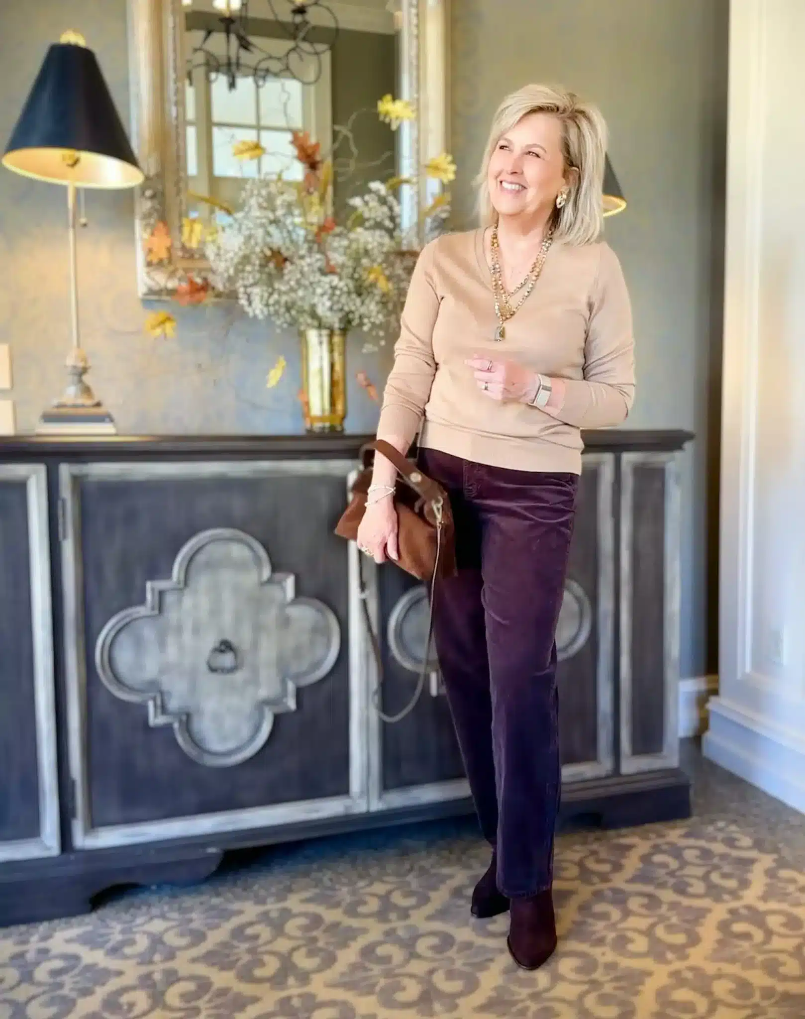 Tania wearing a tan sweater and burgundy corduroy pants