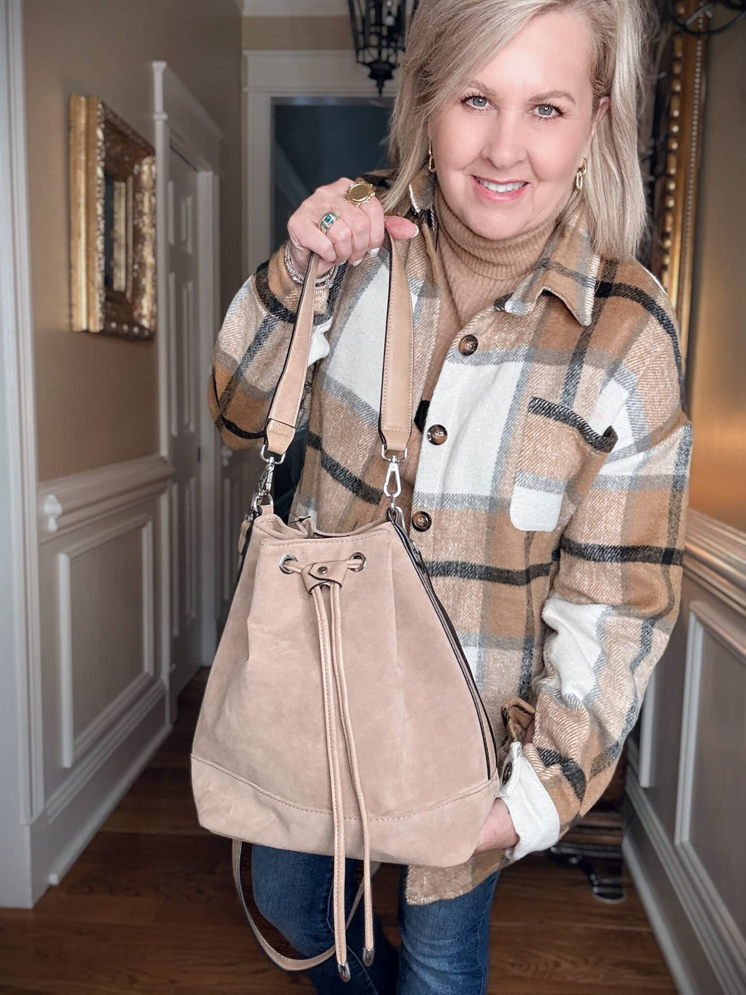 Tania wearing a plaid shacket with a camel bucket bag