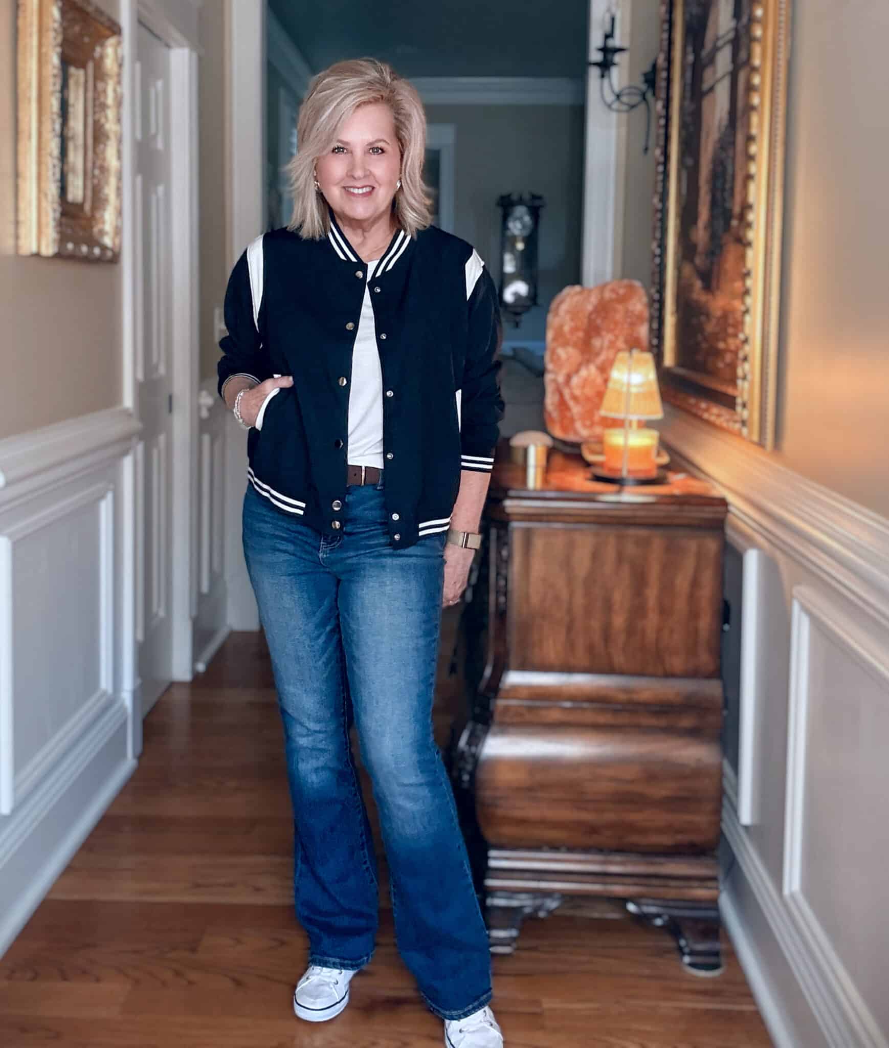 Tania wearing a navy bomber jacket with dark wash flare jeans