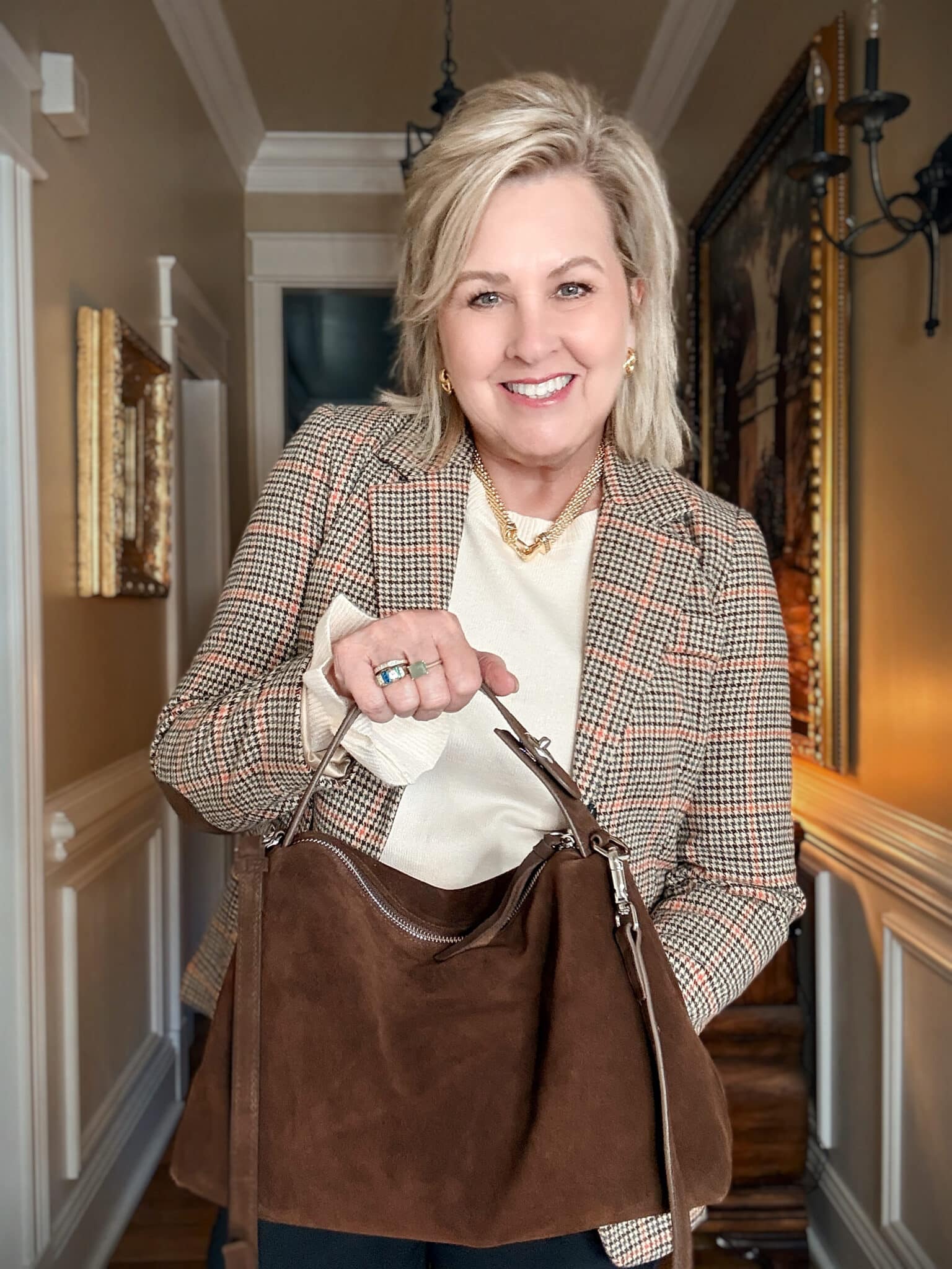 Tania wearing black pants with a plaid blazer with a dark brown handbag from Amazon