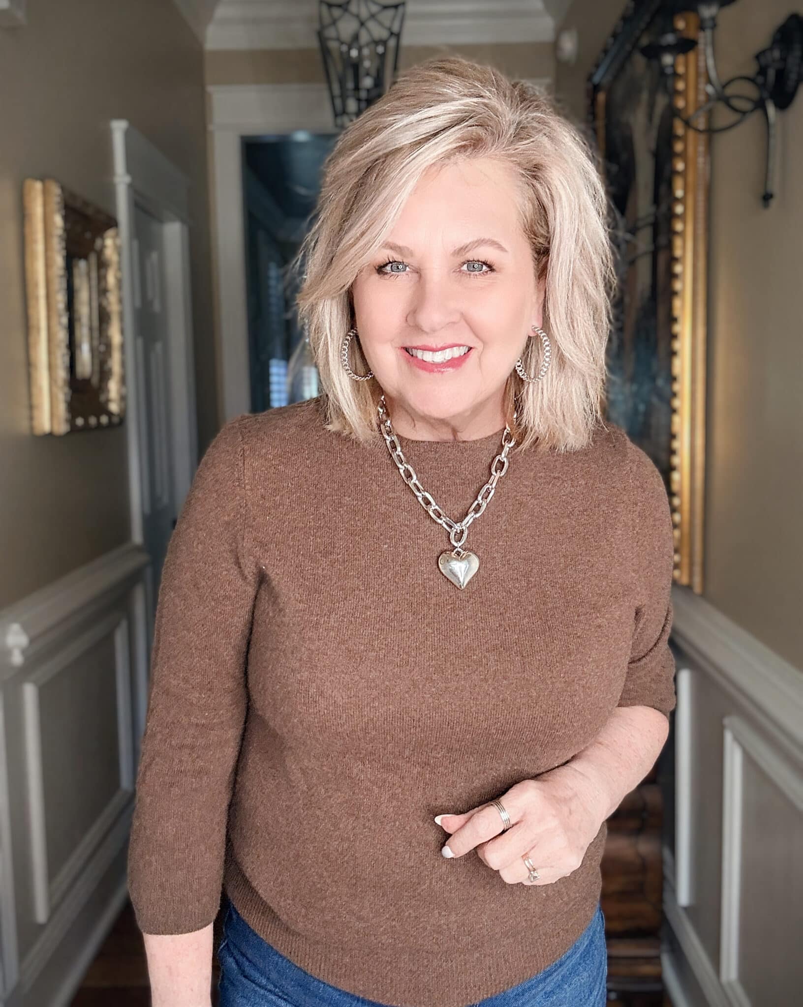 Chunky silver chain necklace styled with a brown sweater, demonstrating a modern statement necklace for women over 50.