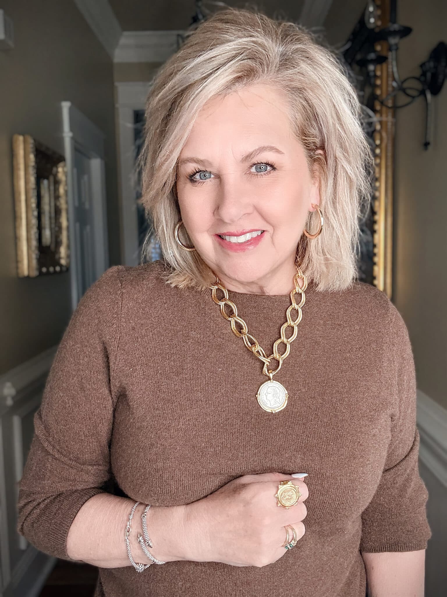 Chunky silver chain necklace styled with a brown sweater, demonstrating a modern statement necklace for women over 50.