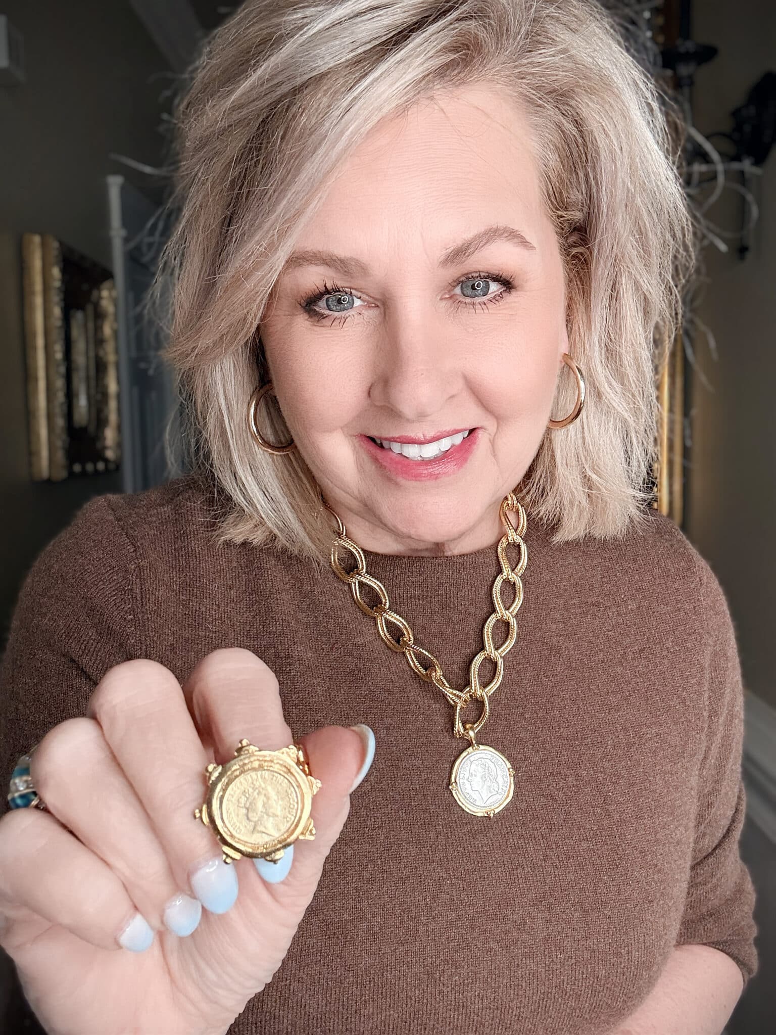 mixed metal franc chain necklace with Queen Elizabeth II Windsor ring styled on brown sweater