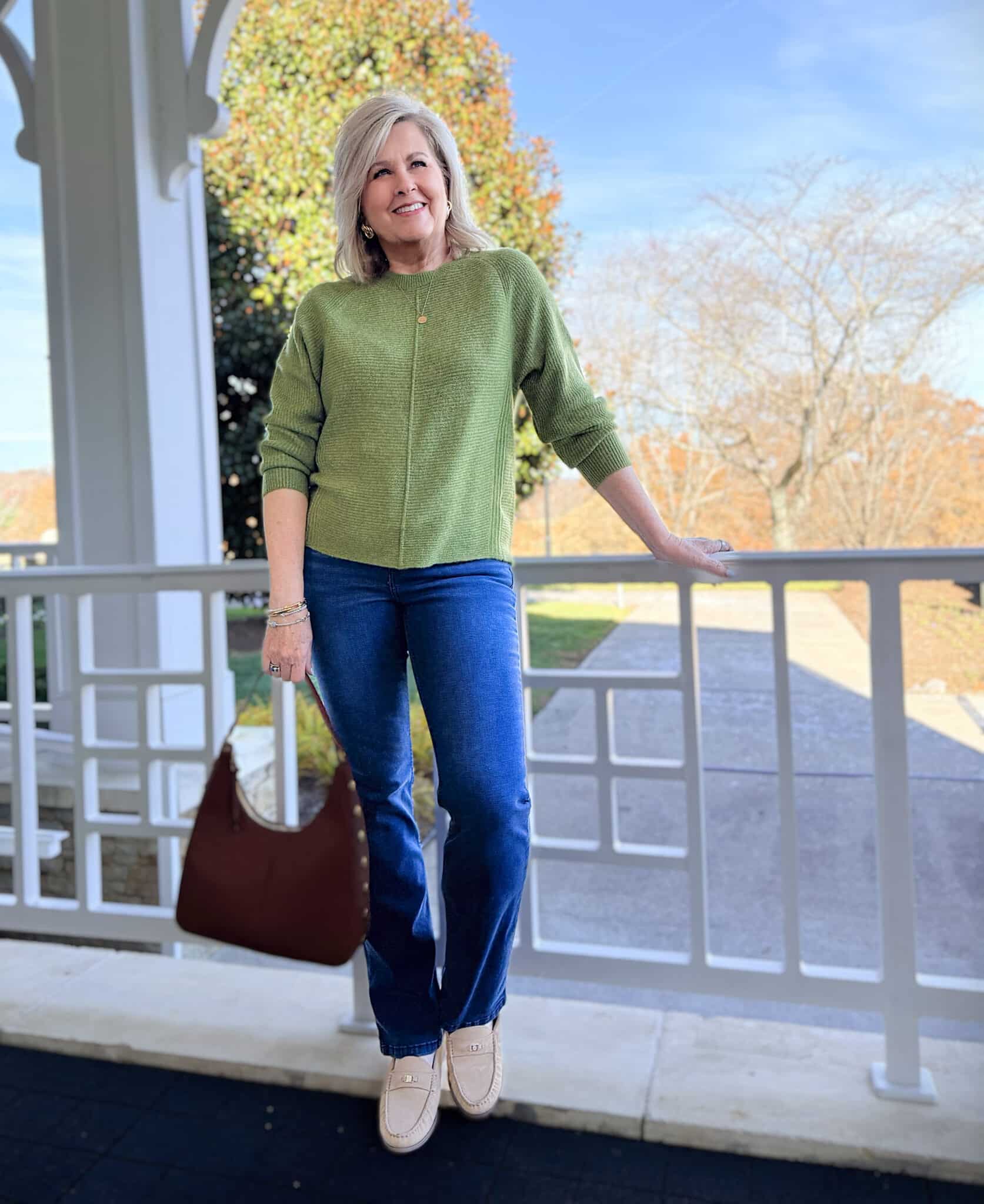Woman wearing cozy green sweater and bootcut jeans from Kohl’s for Thanksgiving outfit inspiration