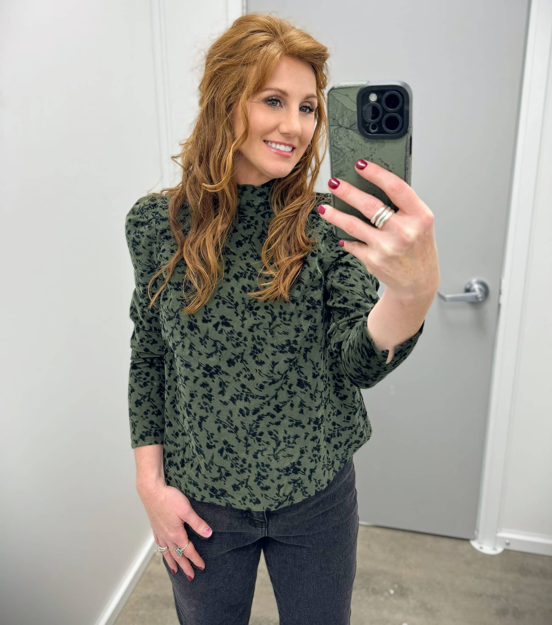 Stephanie wearing black jeans and a green and black top from Walmart