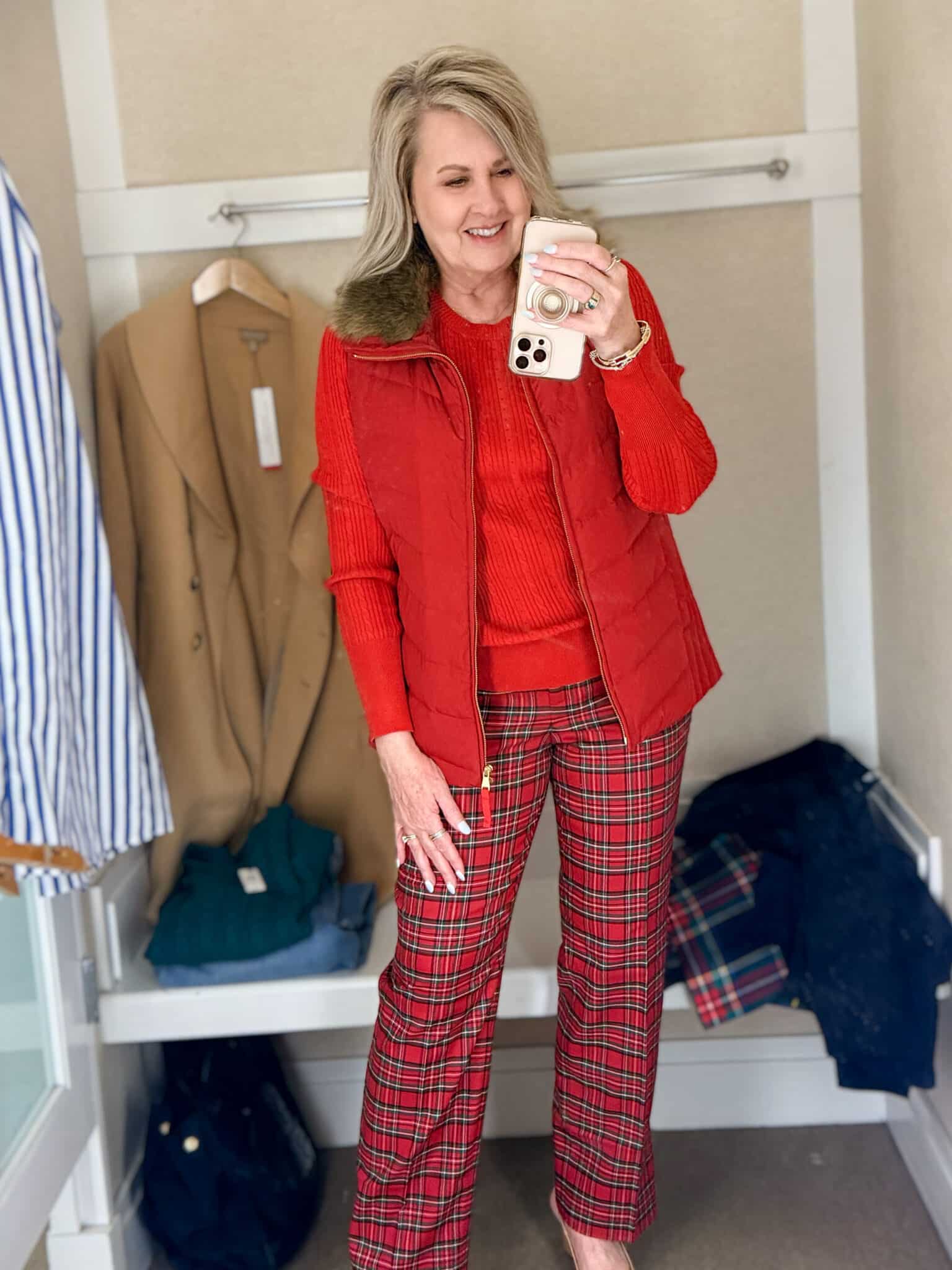 Tania trying on a red sweater with a red vest with a fur collar and red plaid pants from Talbots