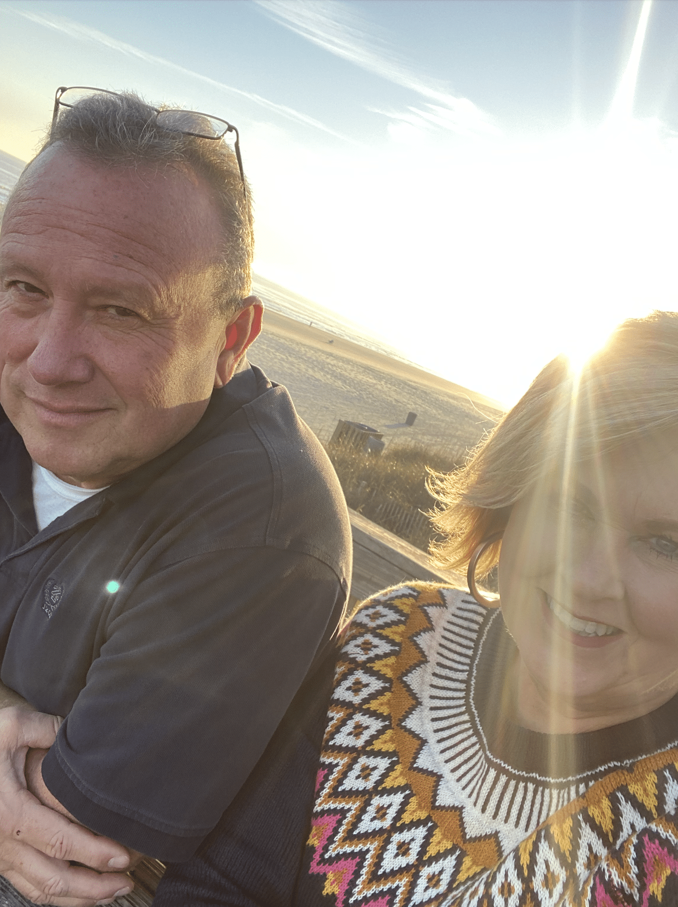 The sun setting at the beach behind Joe and Tania