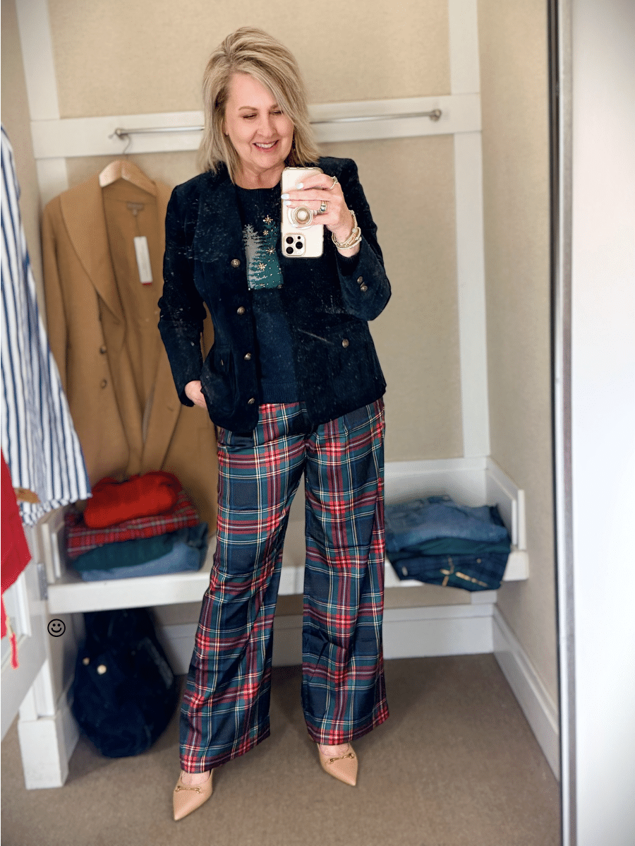 Tania trying on a navy sweater with green Christmas trees and a blue velveteen blazer with blue and red plaid pants from Talbots