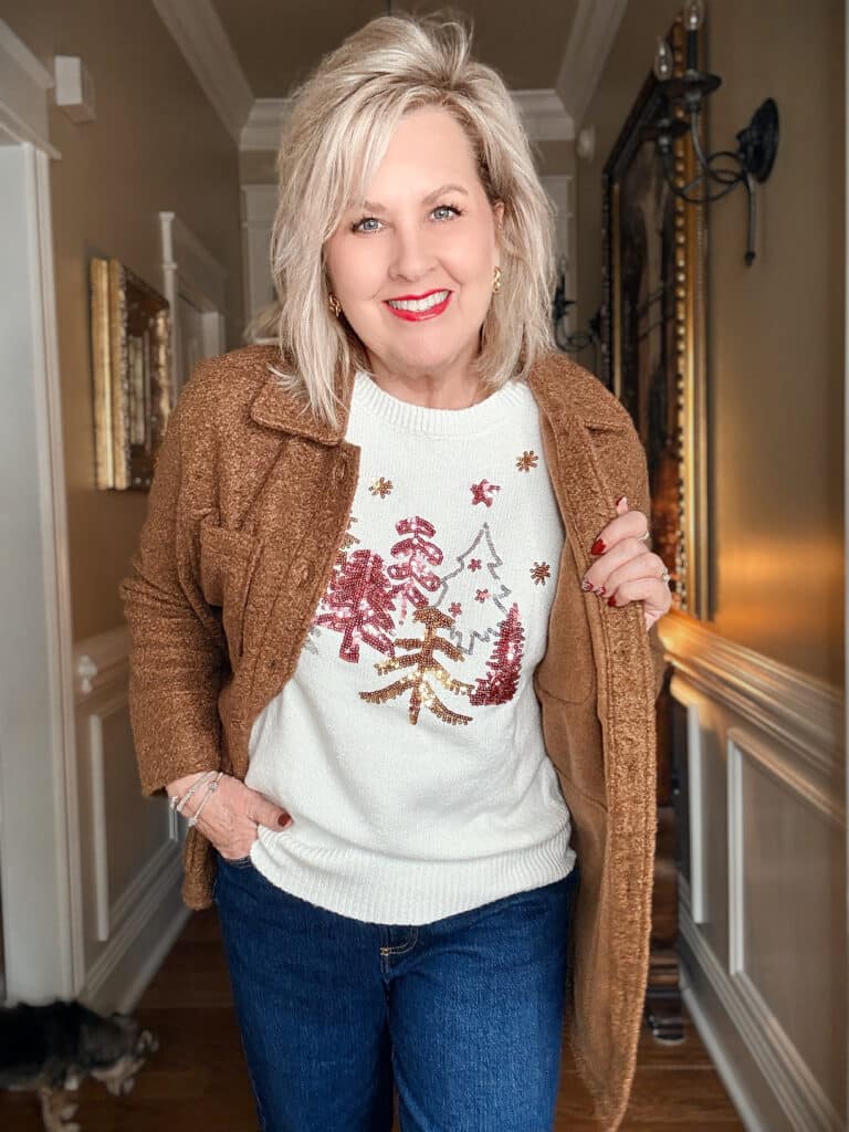 Tania wearing a white holiday sweater with a brown boucle coat from Walmart