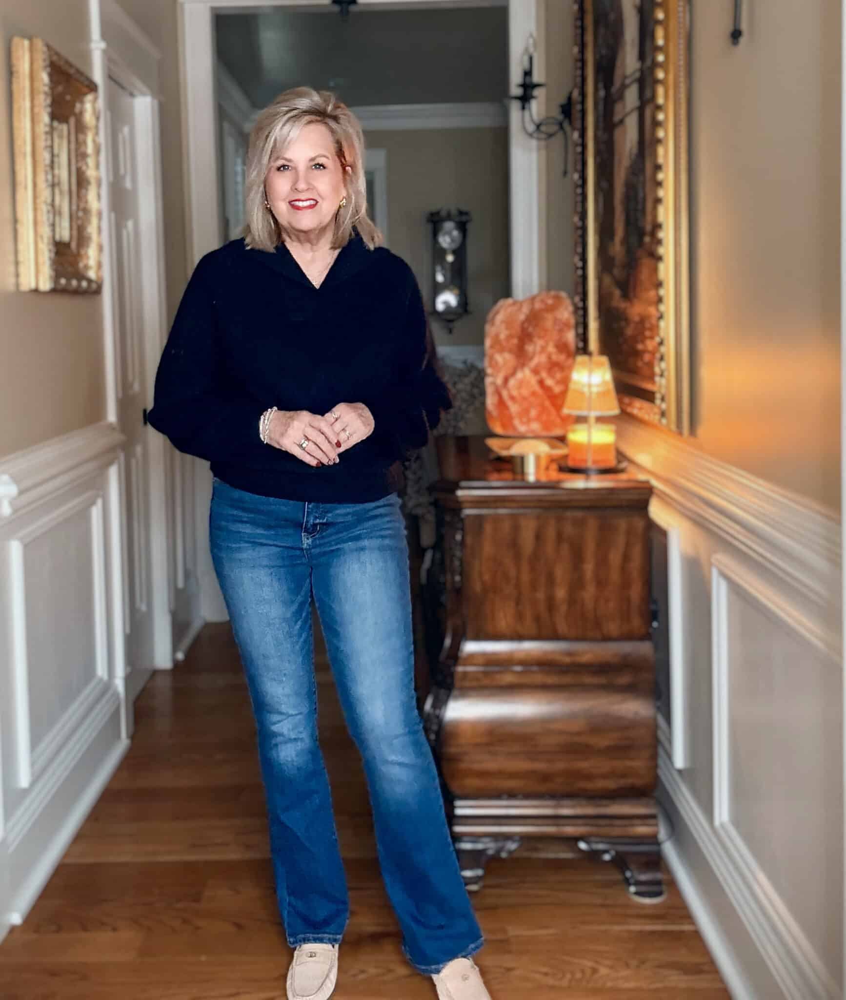 Tania wearing a navy chunky sweater and flare jeans from Walmart