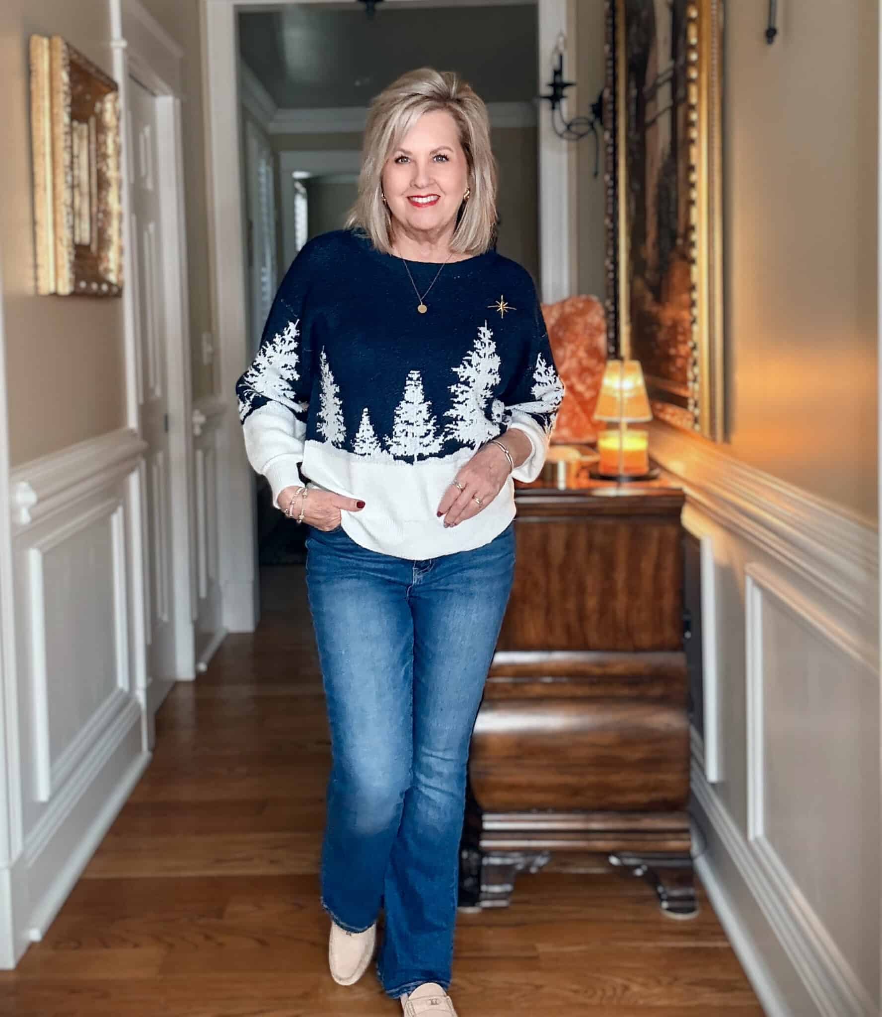 Tania wearing a navy & white holiday sweater with flare jeans from Walmart