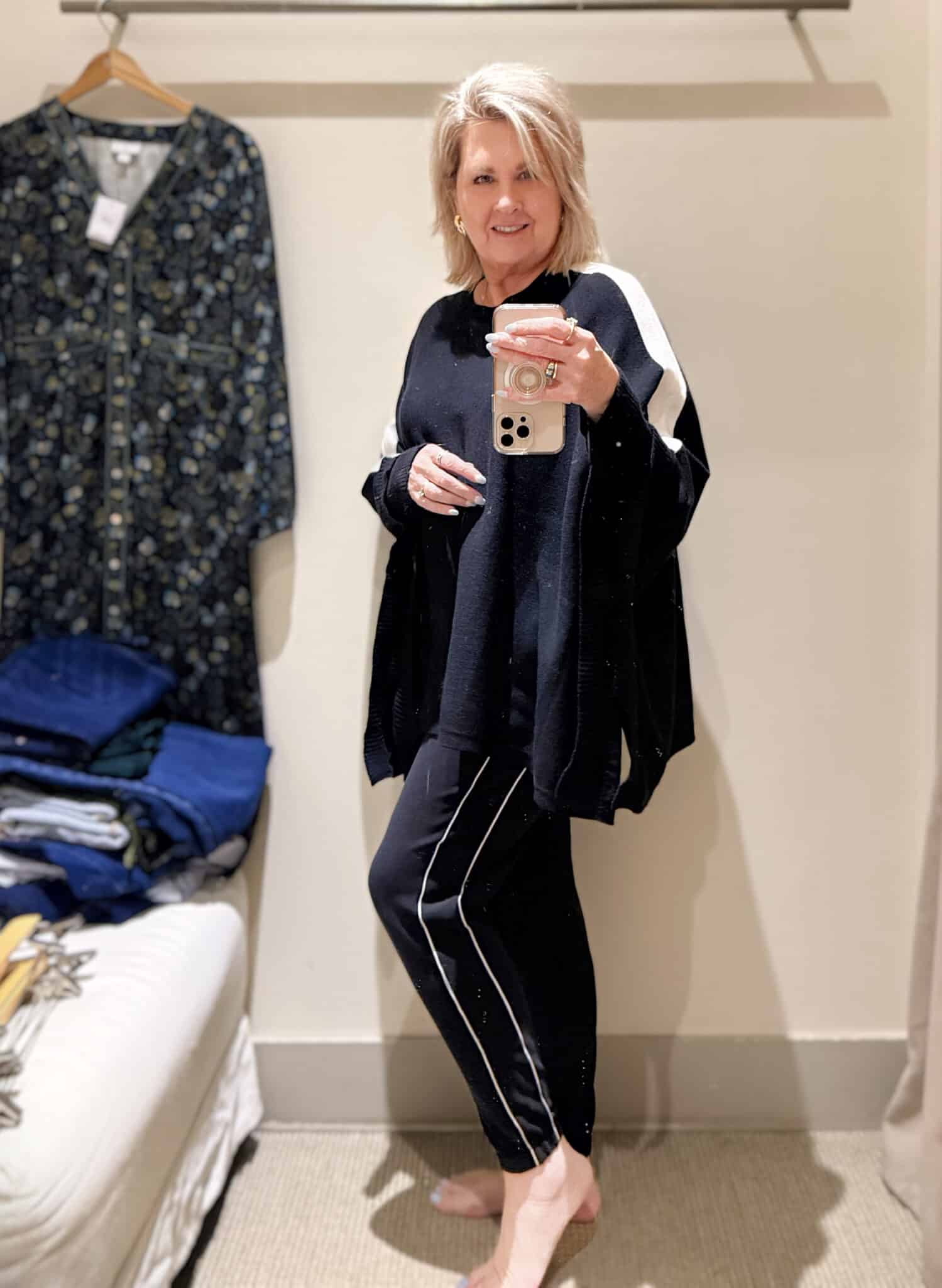 Tania doing a try-on haul at J.Jill  of black joggers and a black poncho with a white stripe