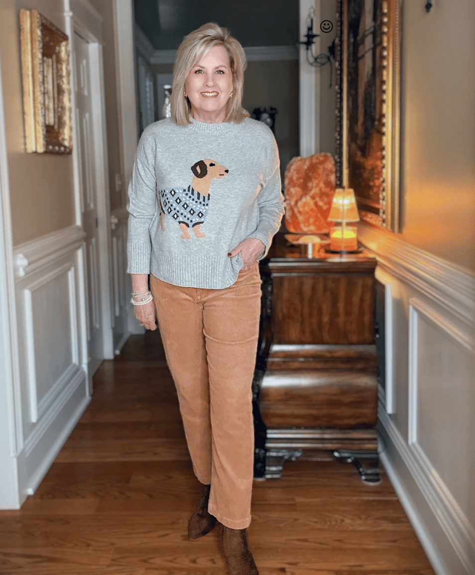 Tania wearing a gray sweater with a brown dachshund dog and corduroy pants from Loft