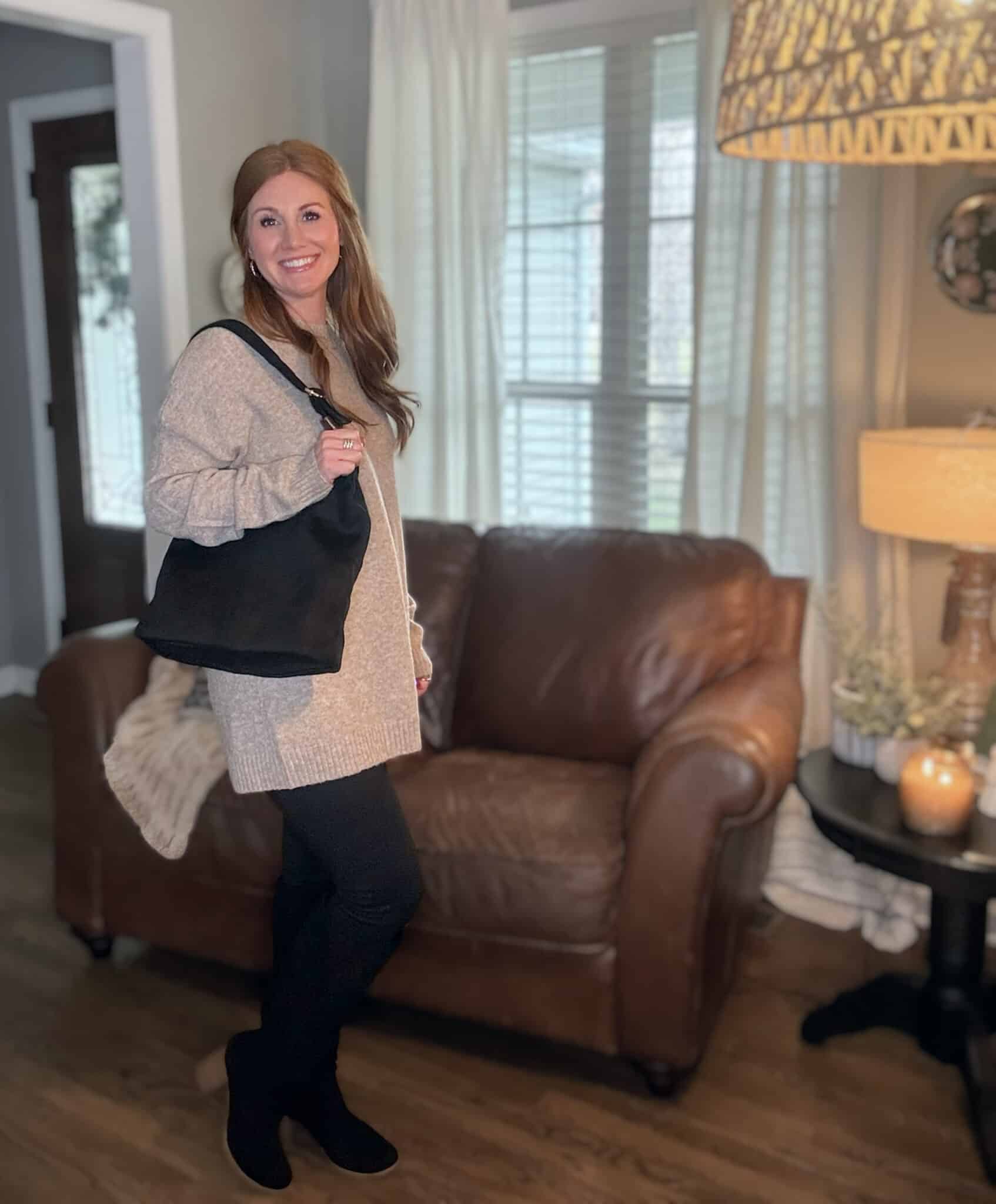 Petite red head wearing a tunic sweater with black leggings and boots from Amazon