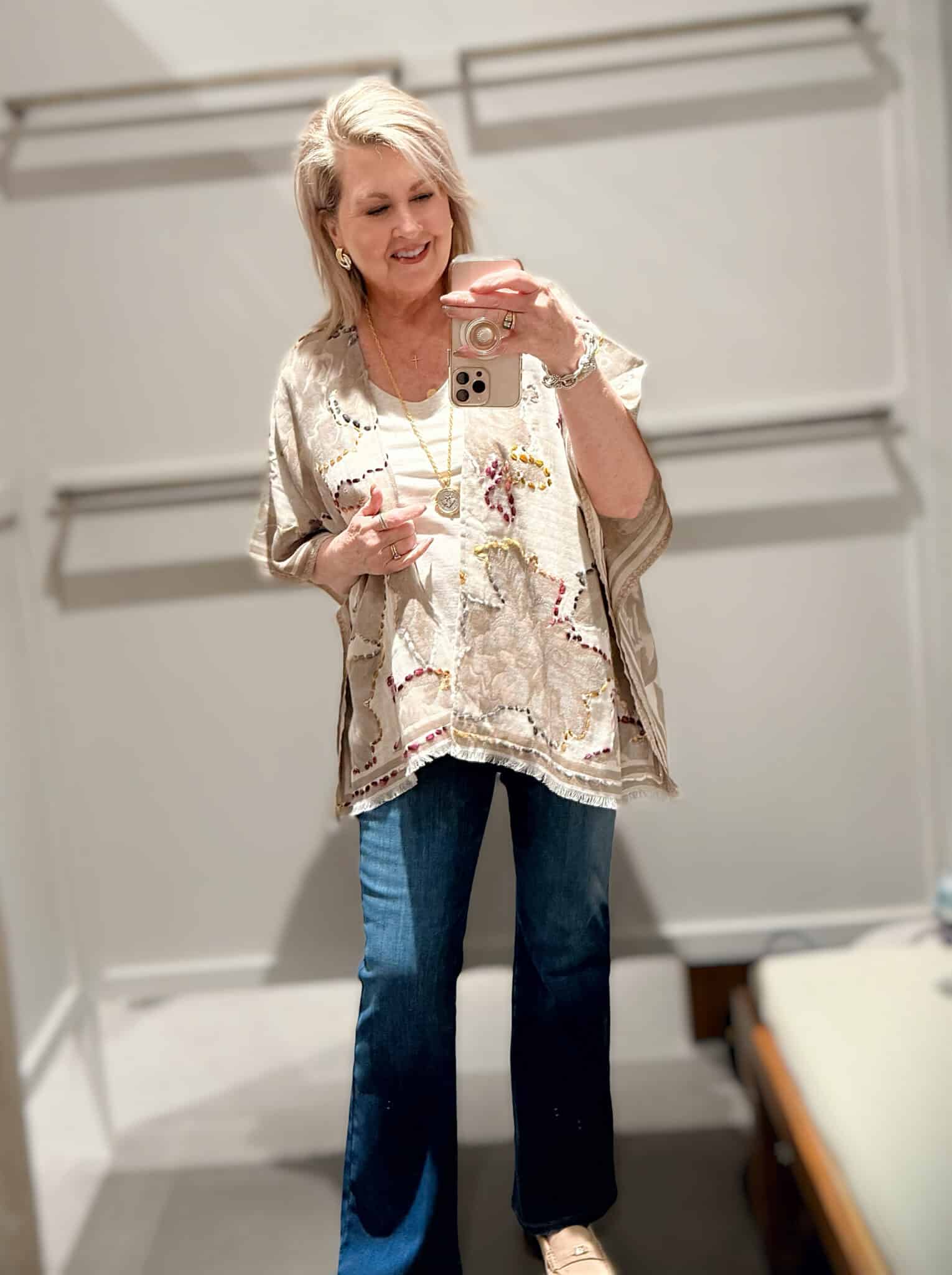 Tania wearing a embroidered ruana and flare jeans from J.Jill