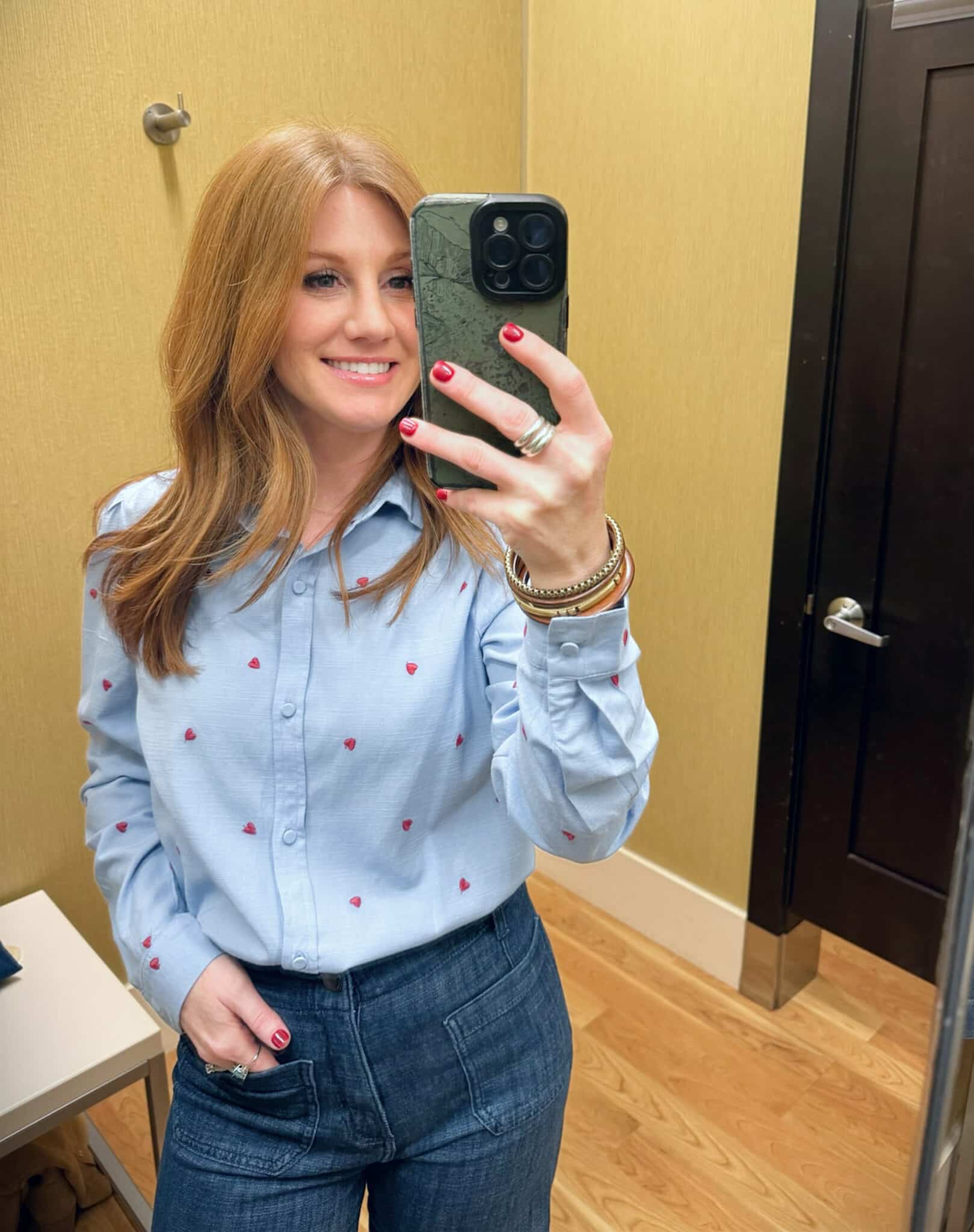 Stylish Petite lady wearing a light blue button up shirt with embroidered hearts