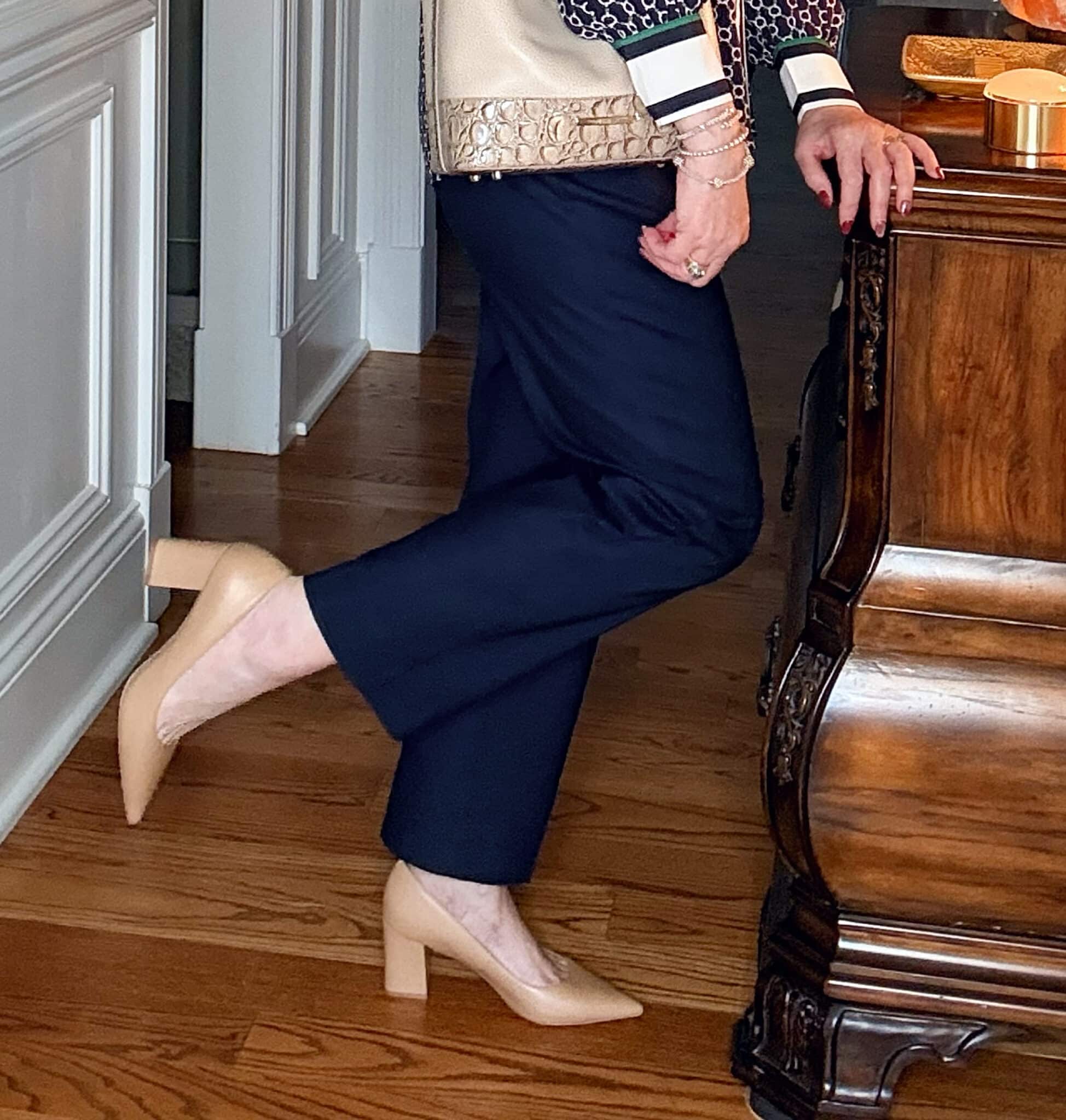 Tania wearing navy pants and nude heels