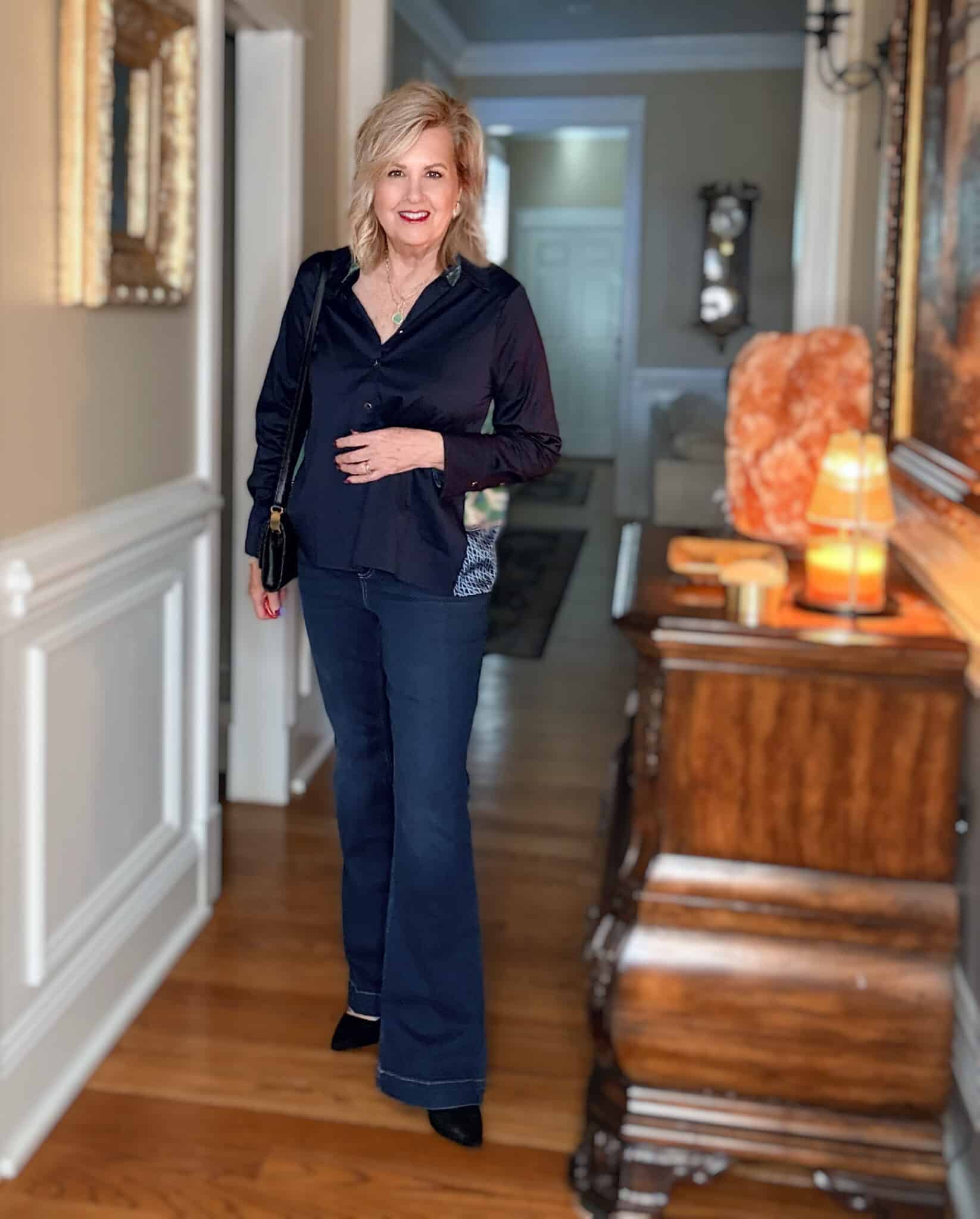 Tania wearing a navy top with faux silk twill pleated back and dark wash jeans