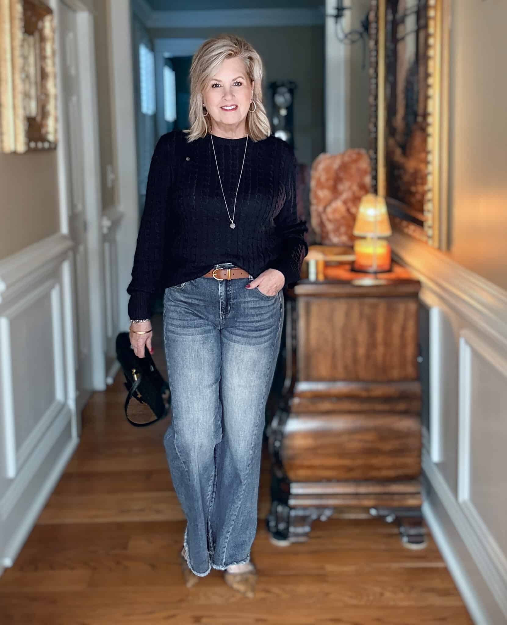 Tania wearing a navy cableknit sweater with frayed jeans