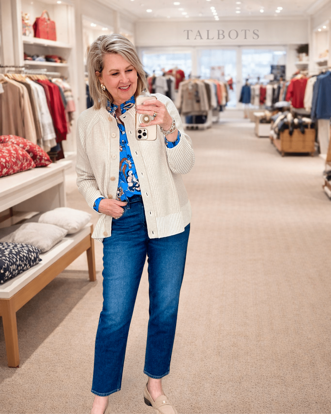 Tania wearing a blue floral top with an ivory cardigan and jeans from Talbots