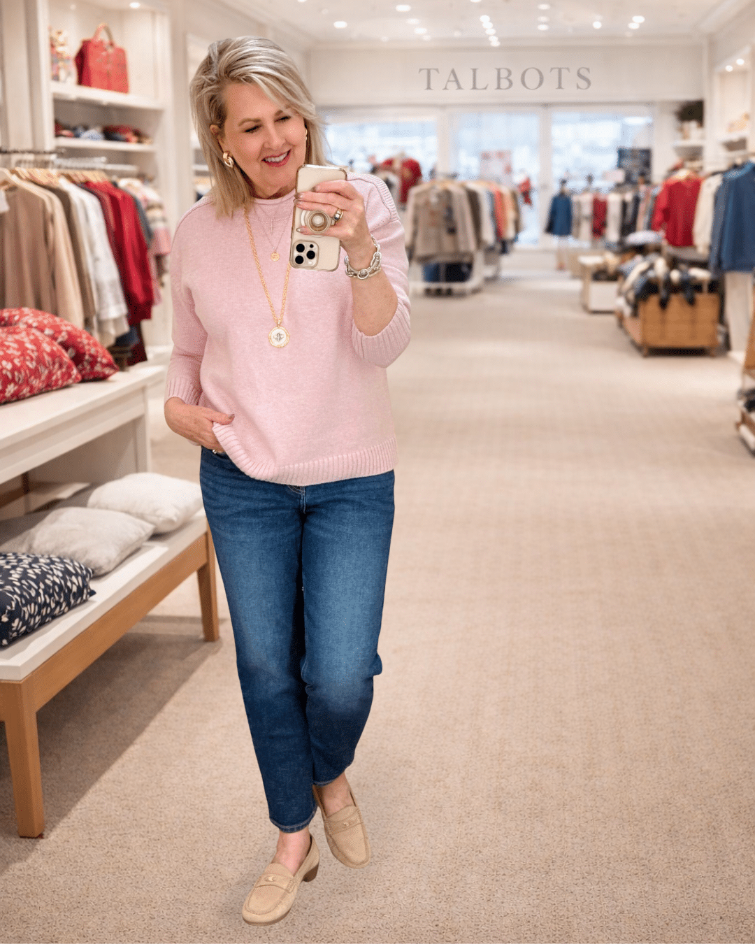 Tania wearing a pink roll neck sweater and jeans from Talbots