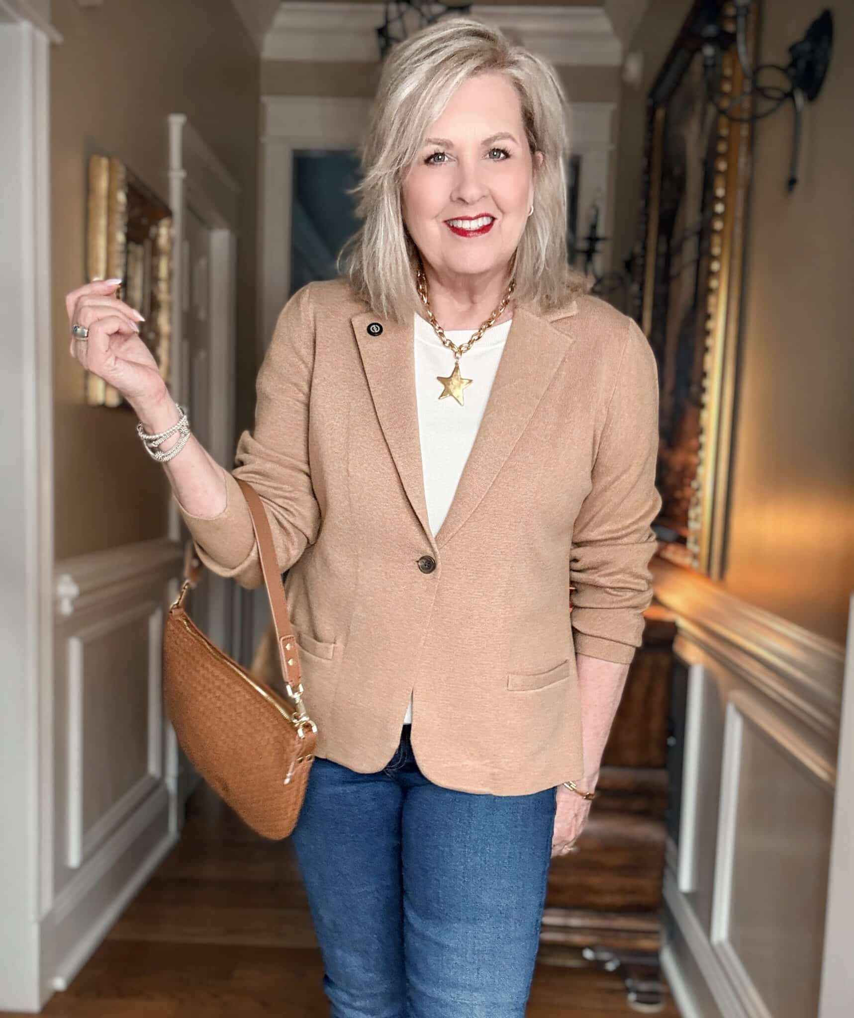 Tania wearing a buttoned tan sweater blazer with a white shirt and a star necklace