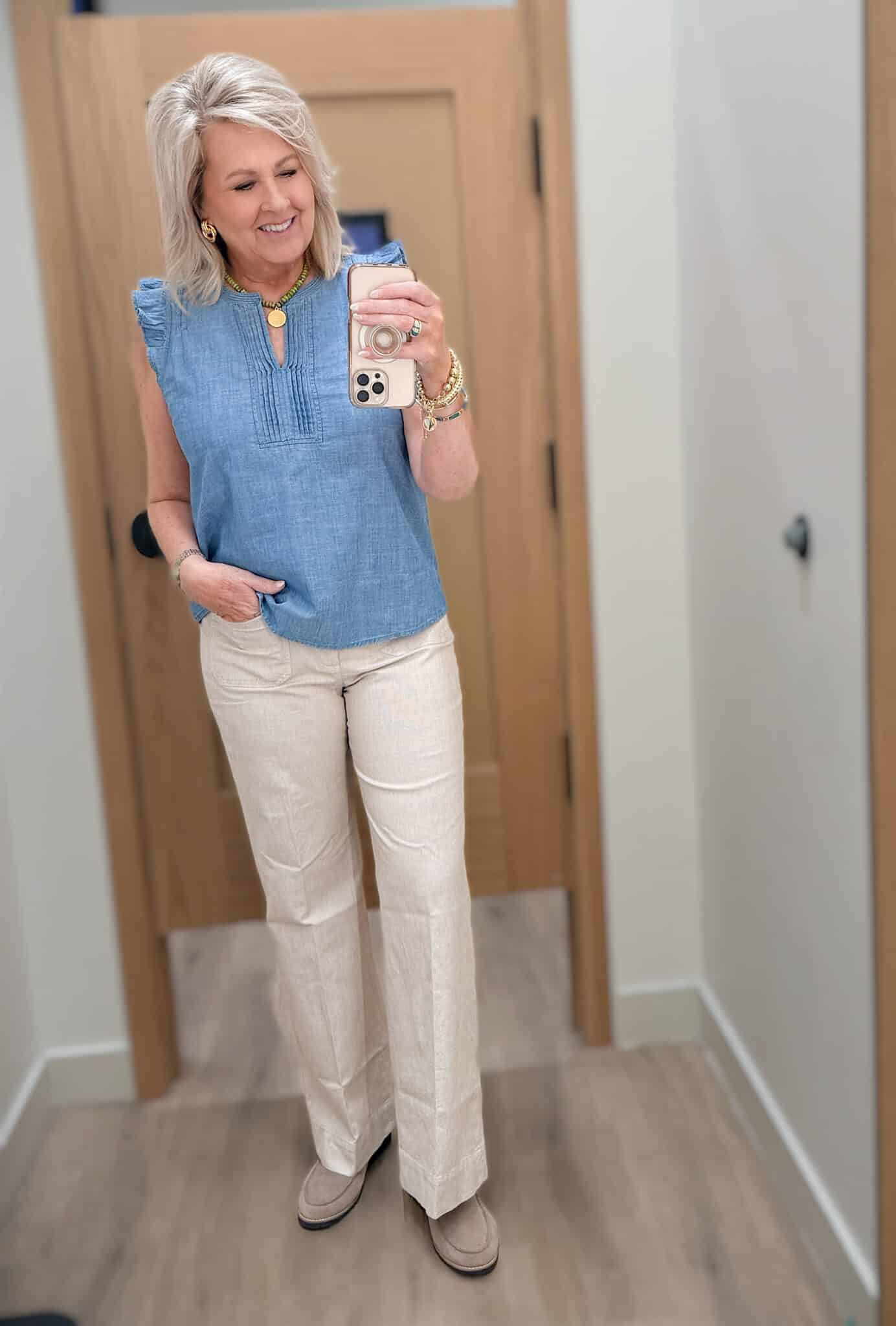 Tania wearing a ruffled sleeve v-neck chambray top with beige striped pants from J.Crew Factory