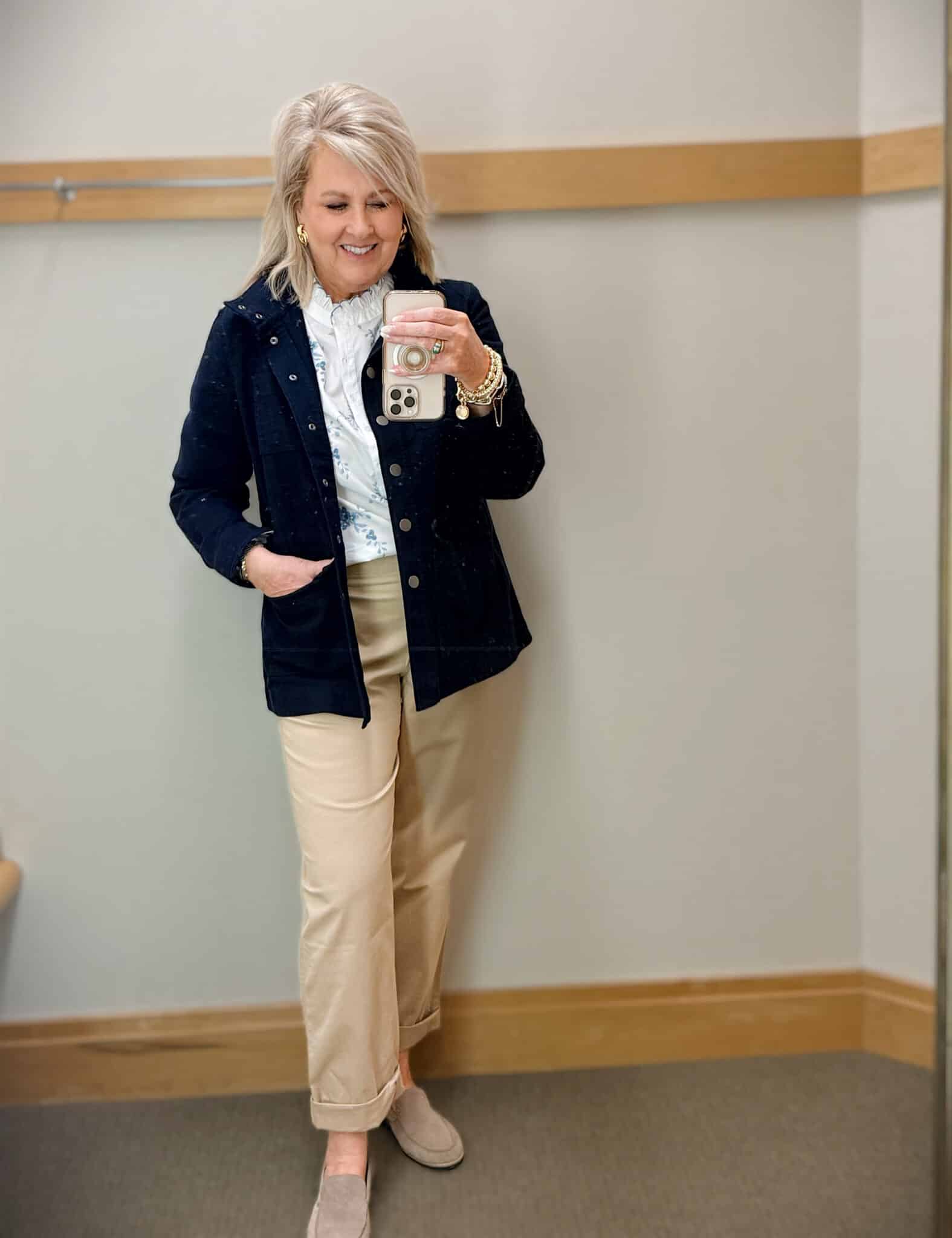 woman over 50 wearing twill utility jacket with floral top and chinos layered spring outfit