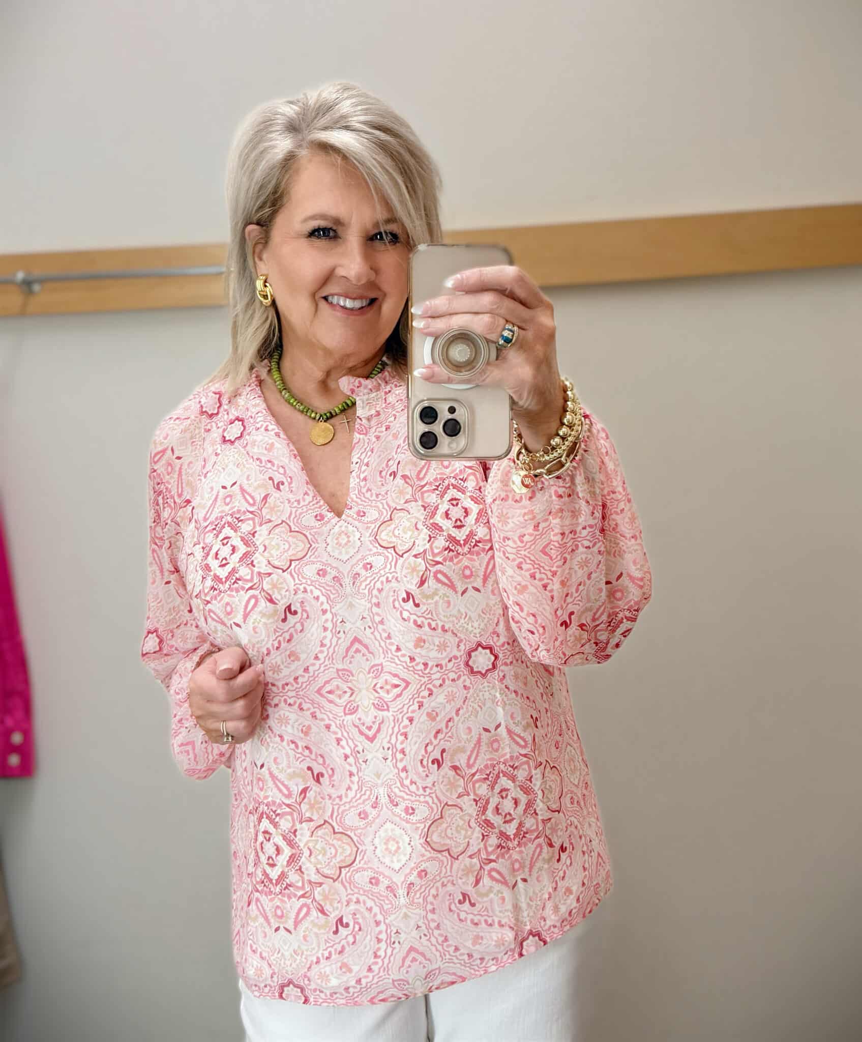 woman over 50 wearing pink paisley top for a feminine spring outfit